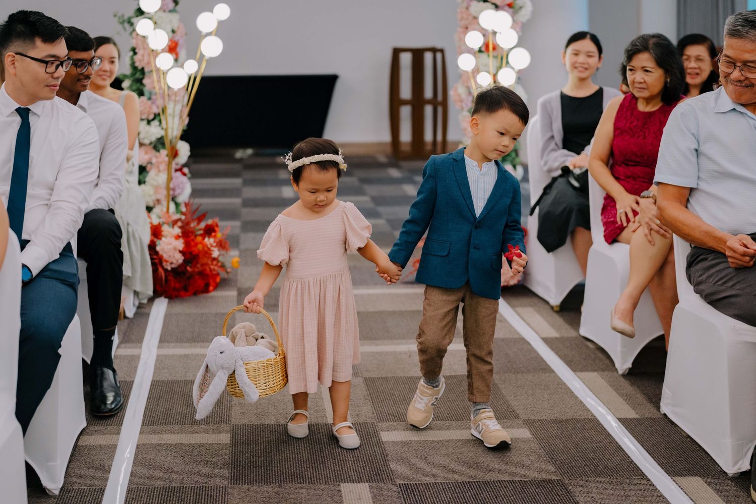 flower girl and paige boy holding hands down the aisle