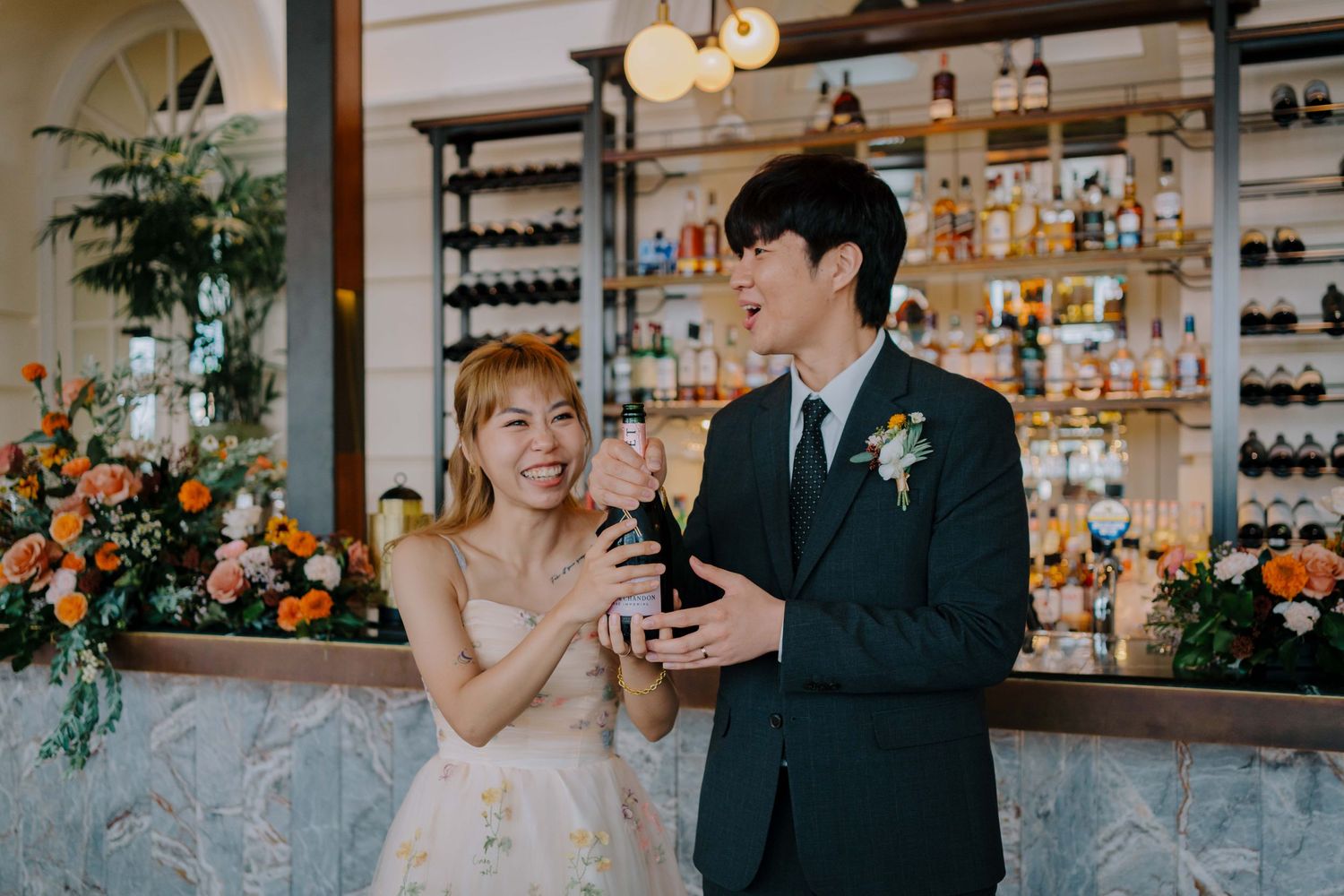 bride and groom pop champagne at empress singapore