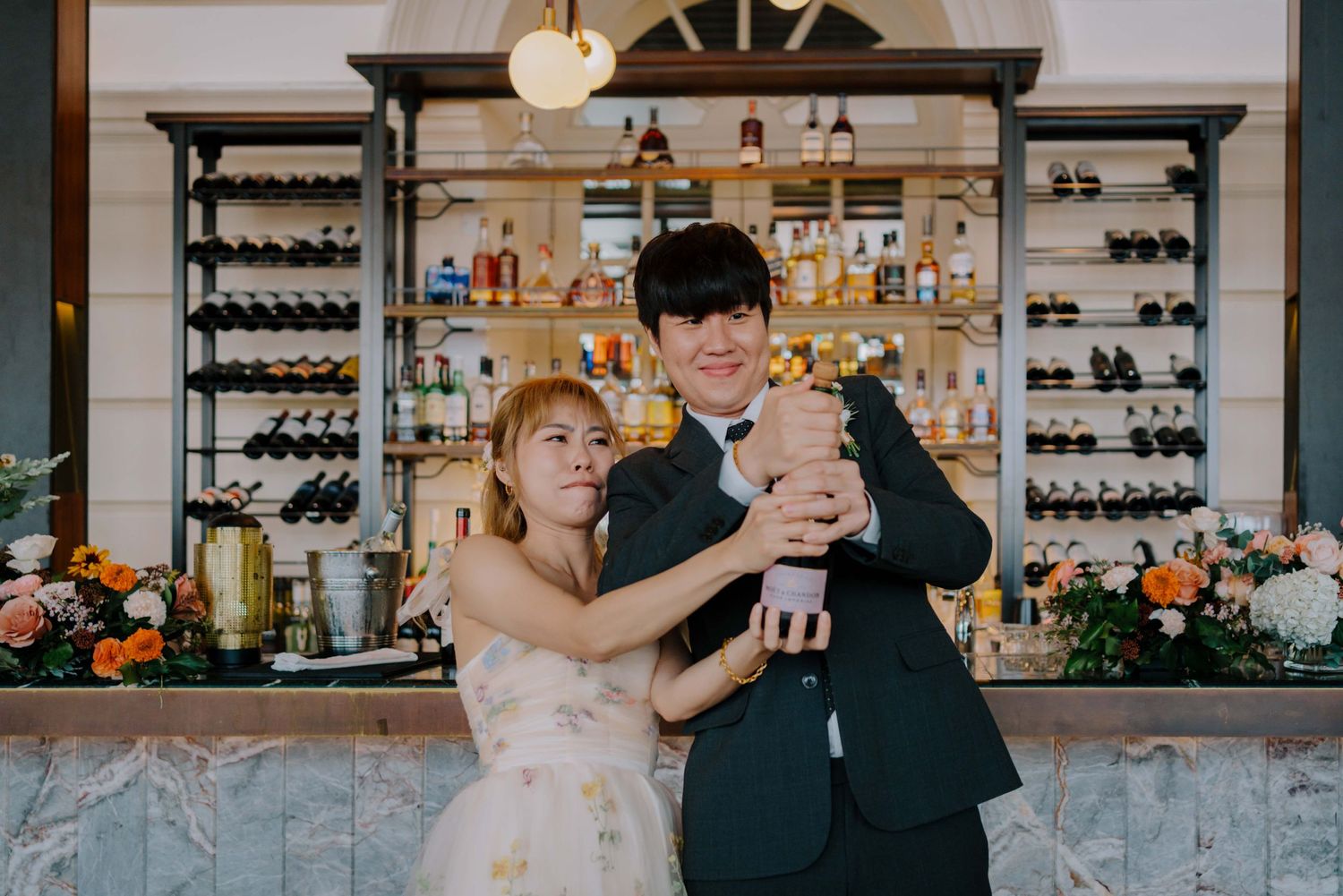 bride and groom pop champagne bottle