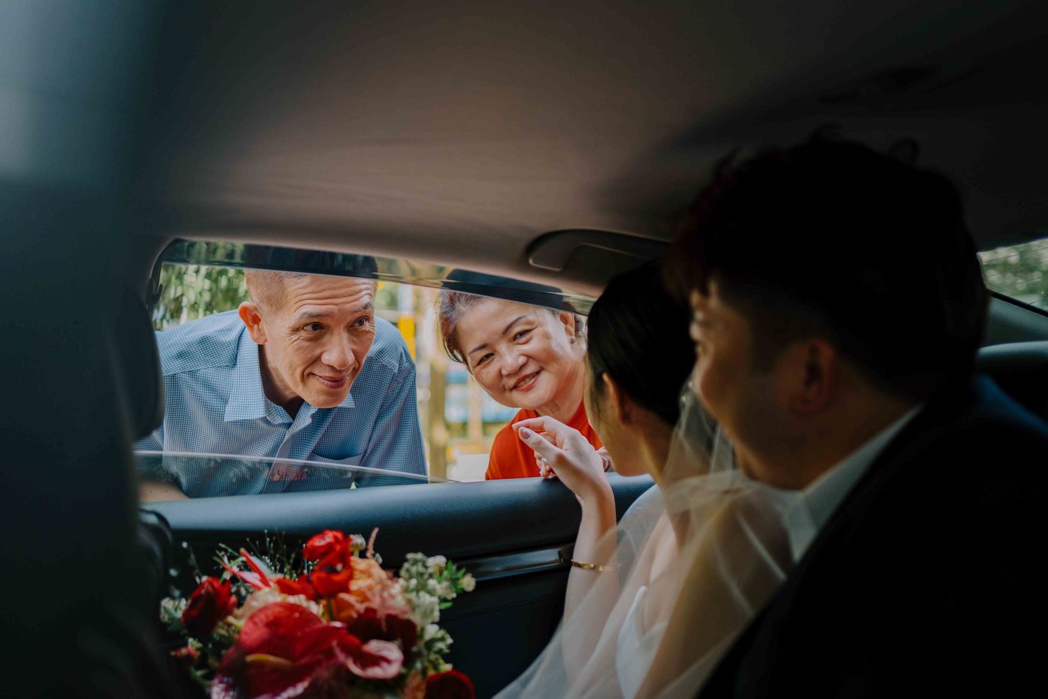 father and mother of bride waving goodbye to her daughter and new son-in-law