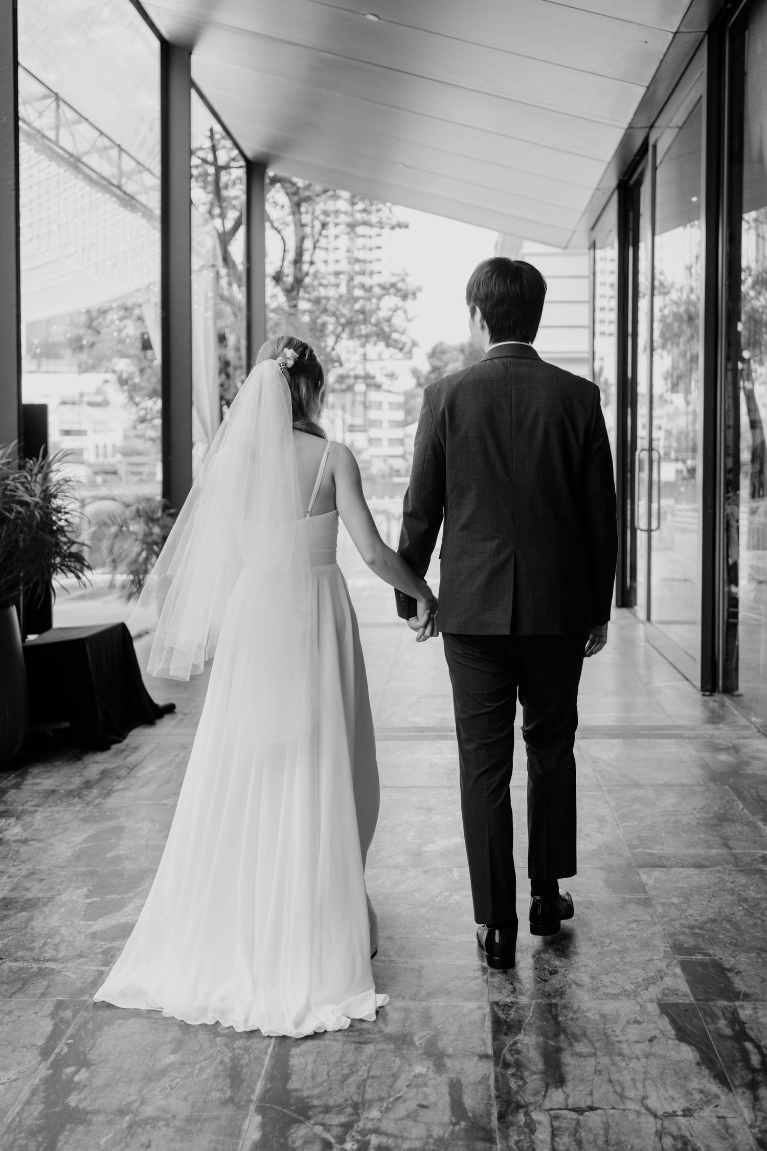 black and white shot of bride and groom march out as newlyweds
