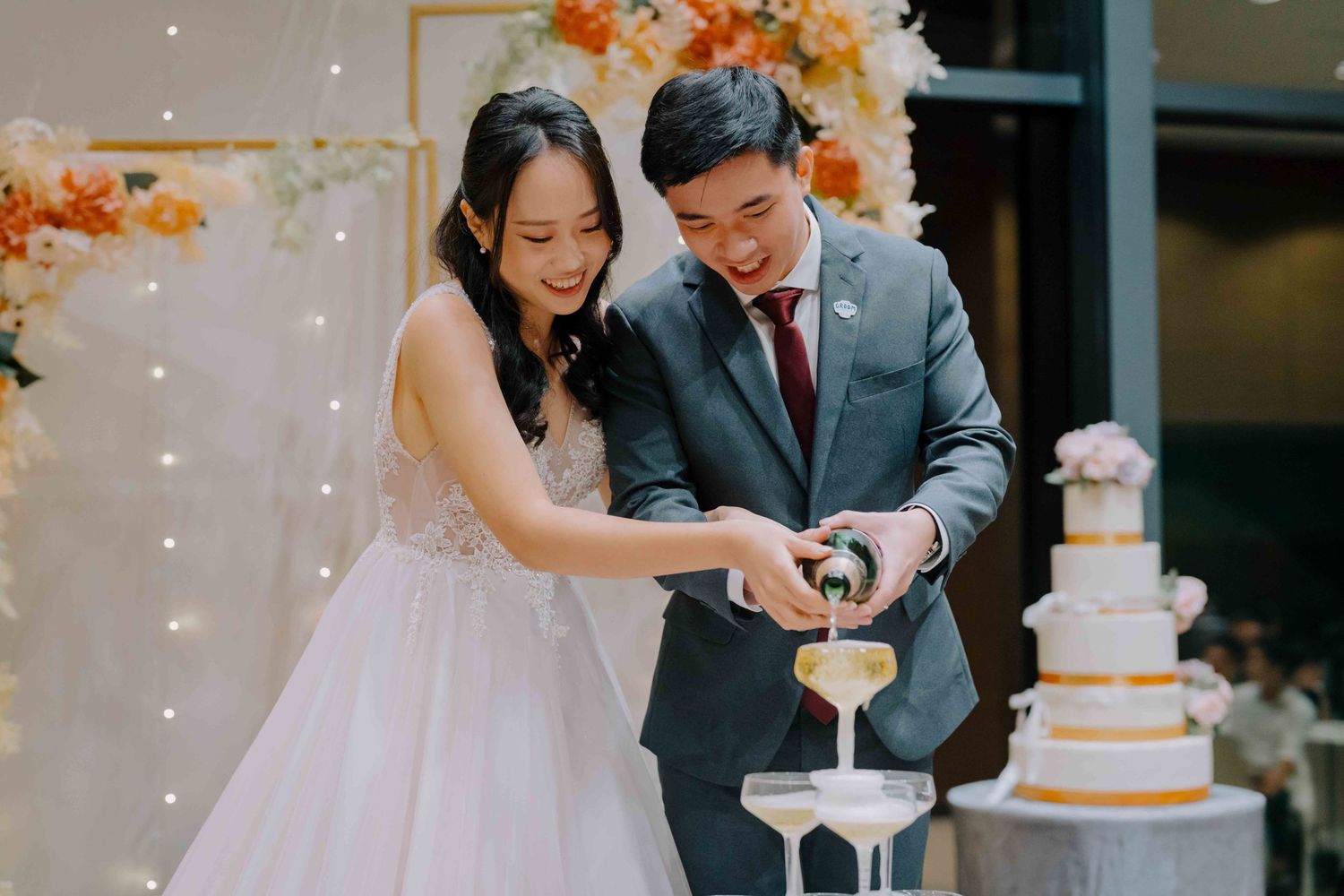 bride and groom pour champagne onto glasses at one farrer hotel singapore