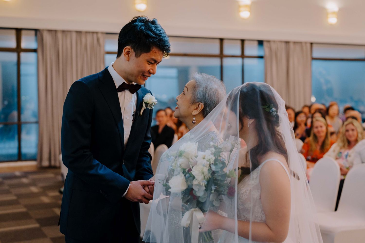 bride and groom meet at the aisle, accompanied by bride's mother