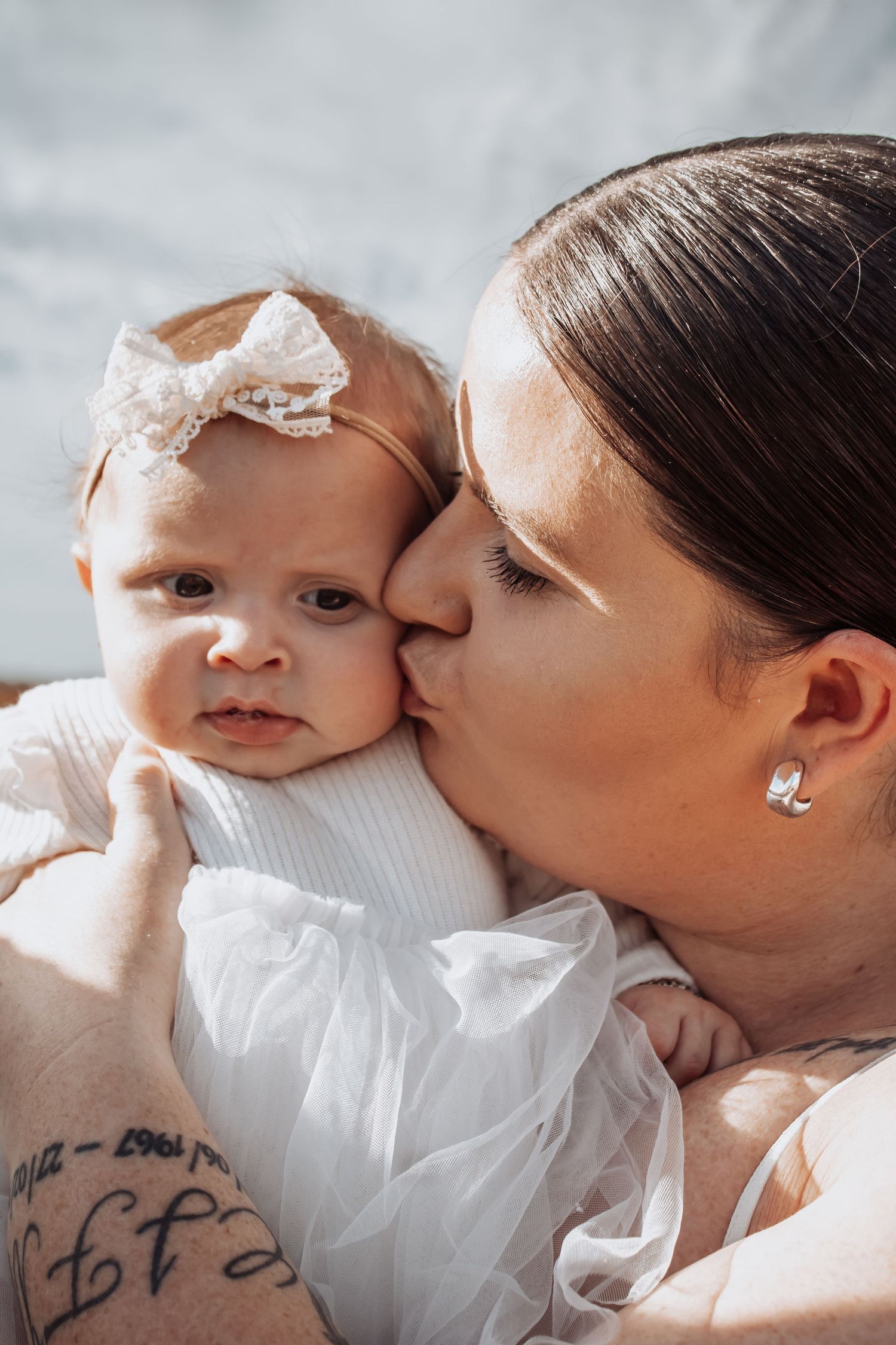 A tender moment between parent and baby in white, captured in a series of intimate close-up photographs.