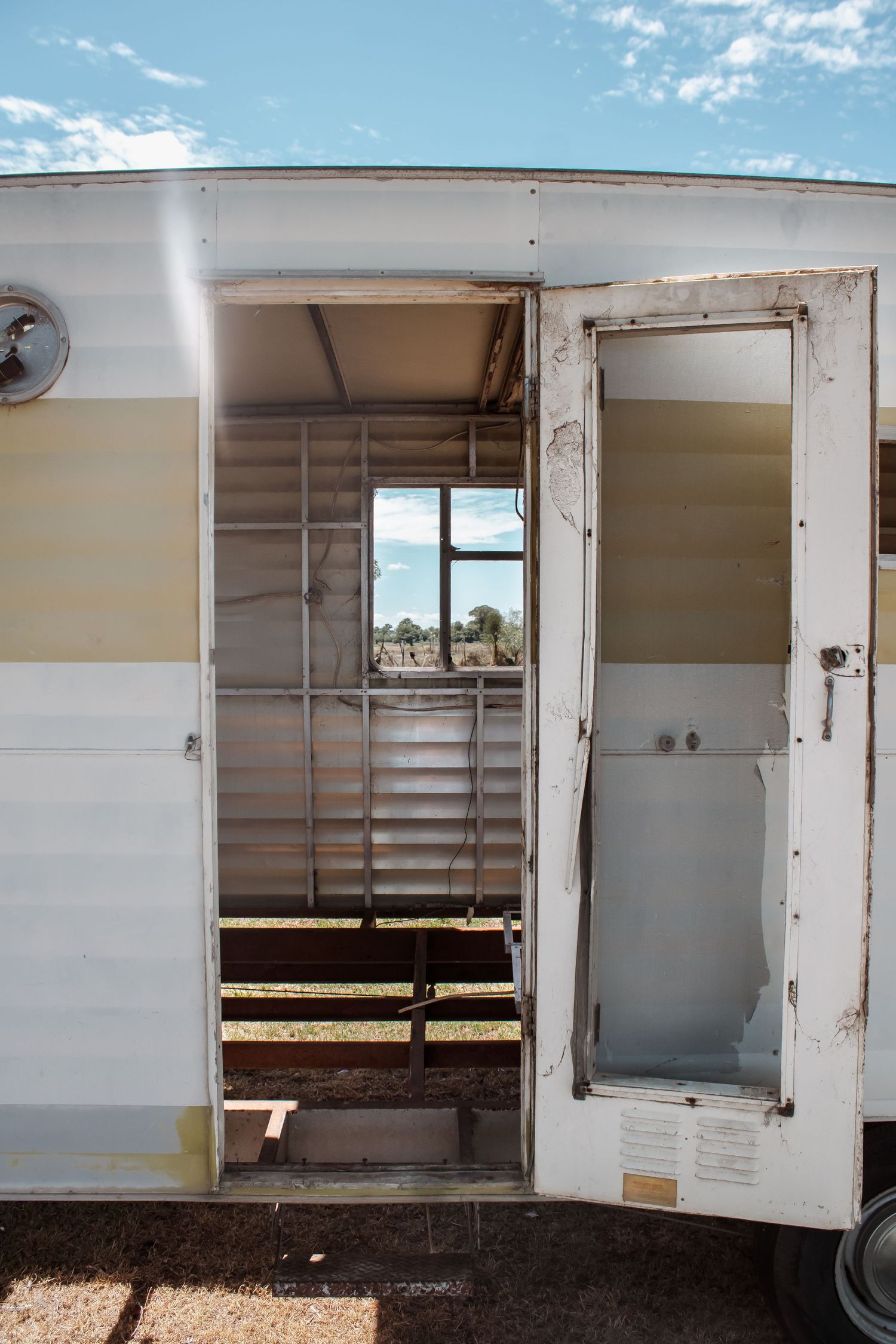 Interior view of white horse trailer showing multiple storage compartments and windows along the side panels.