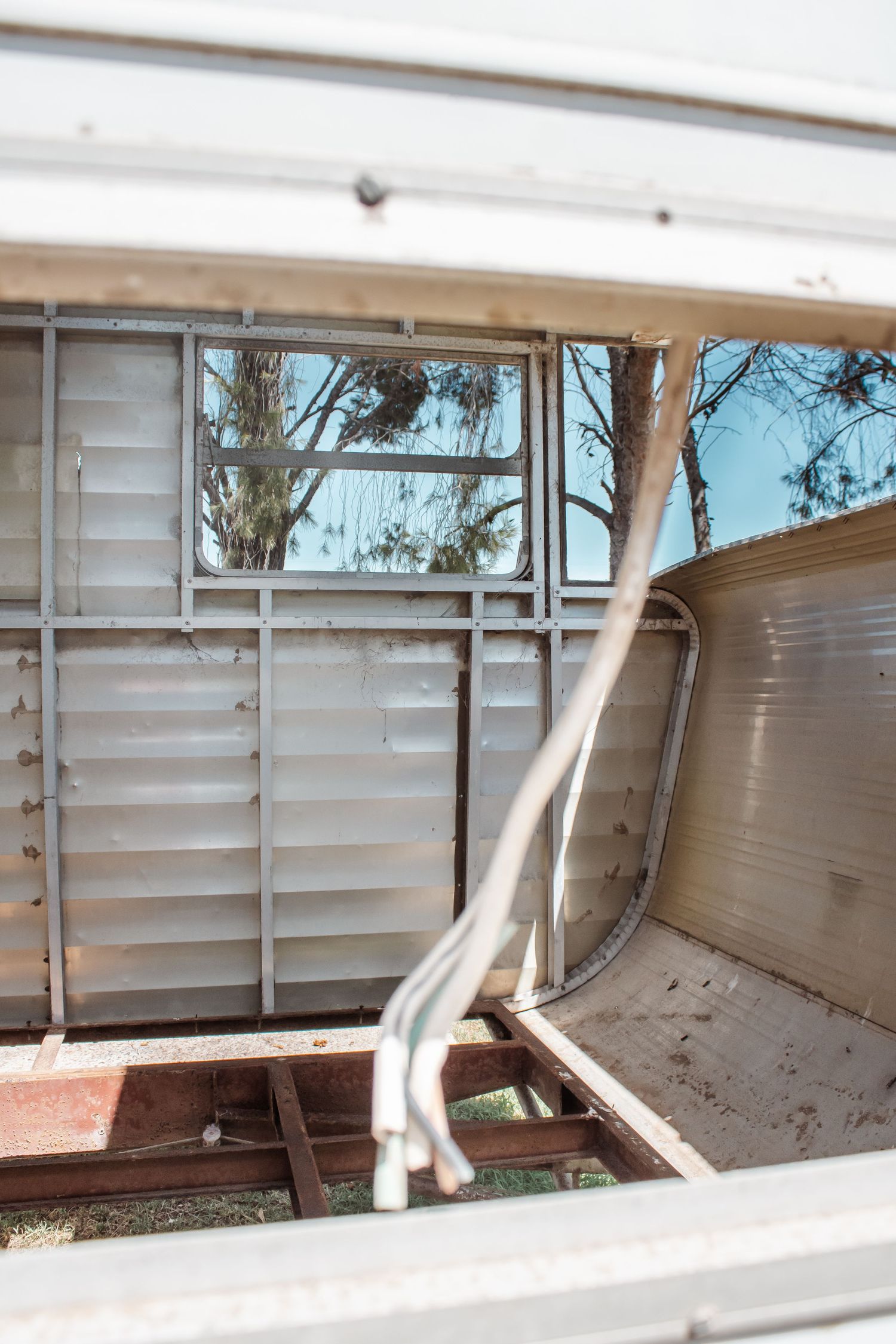 A sequence of aluminum storm shutters being closed in stages to protect windows from severe weather.