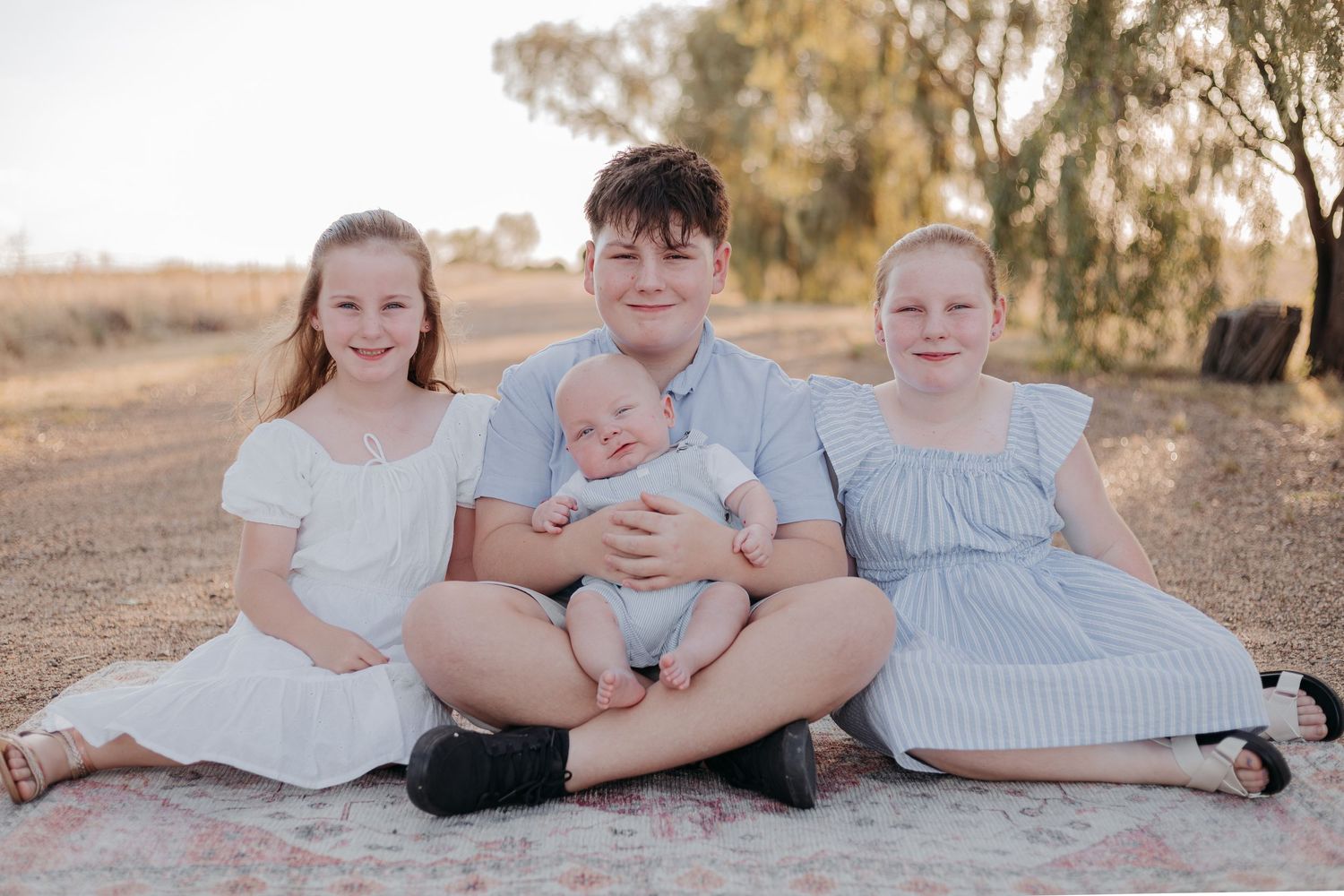 A series of family portraits showing children and parents lying together on the ground in a desert landscape setting.