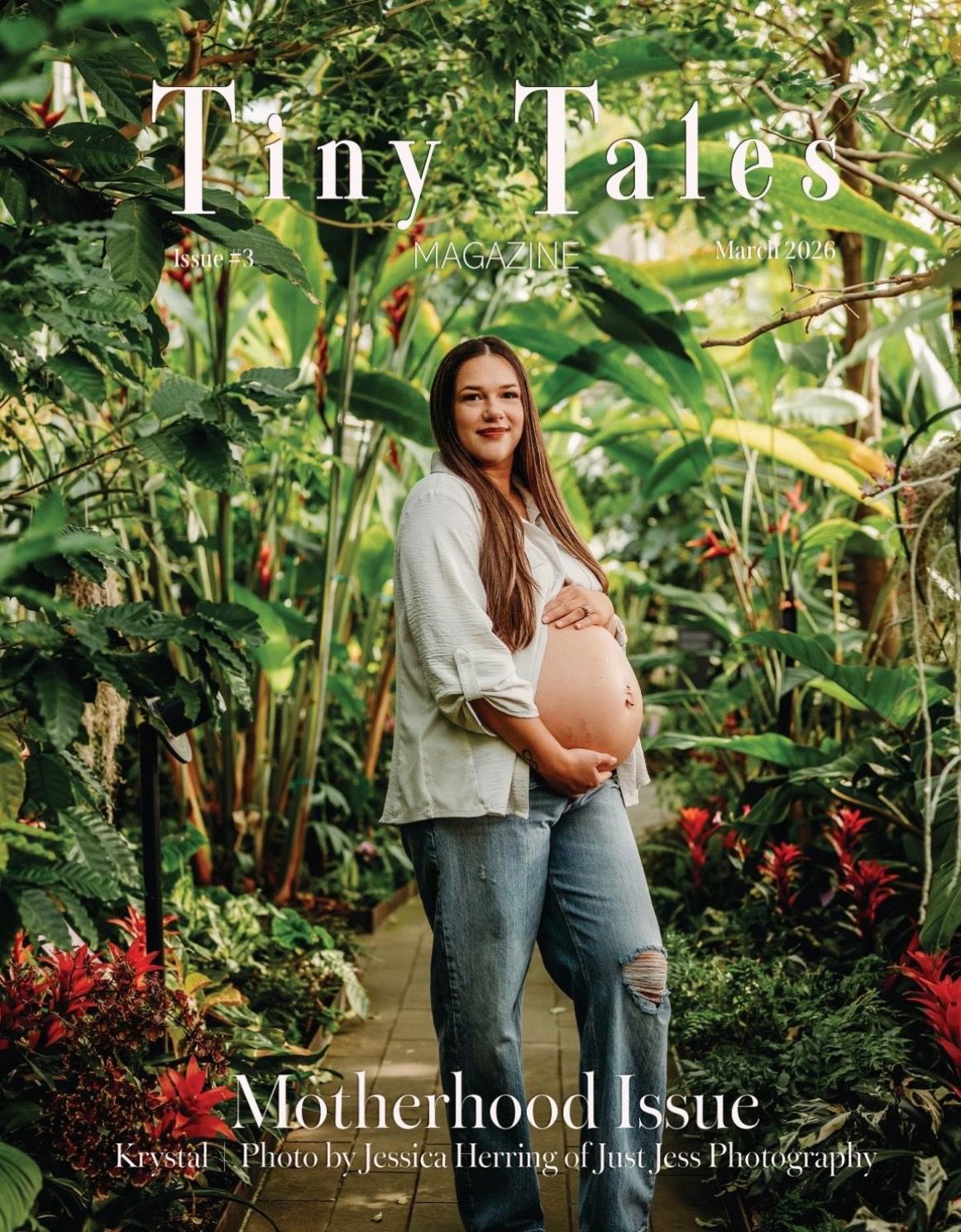 Pregnant woman in white top and jeans poses in lush greenhouse on Tiny Tales Magazine Motherhood Issue cover.