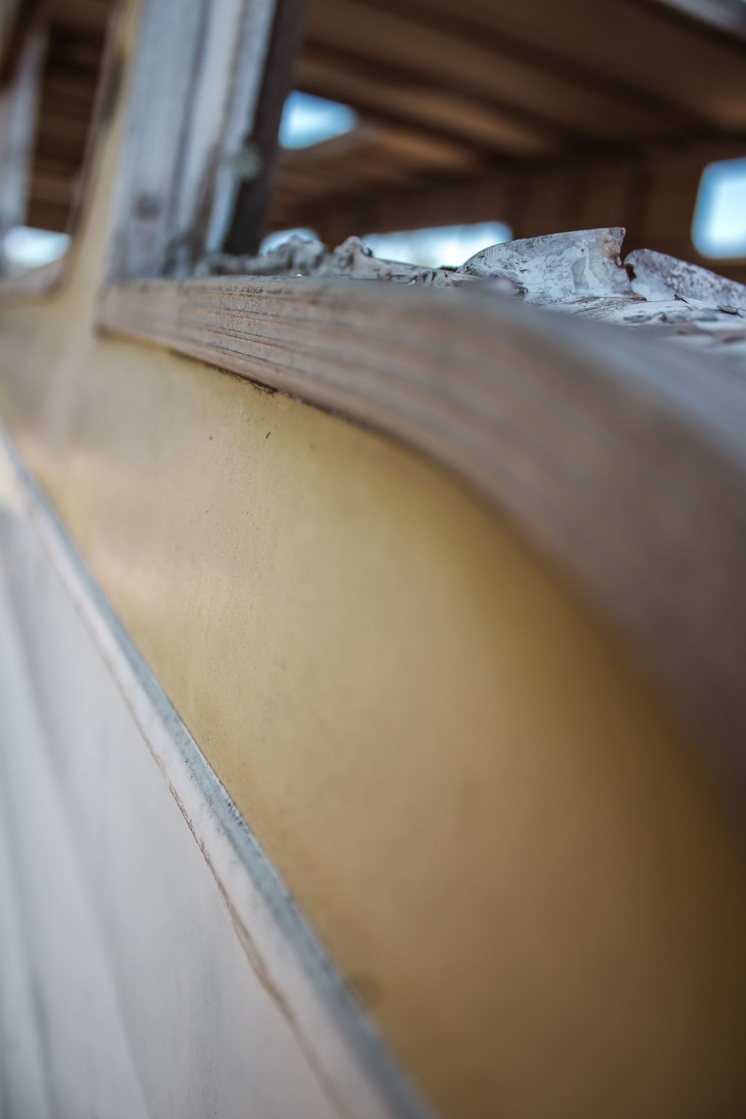 Close-up view of a curved architectural detail showing a beige wall and white trim in shallow depth of field.