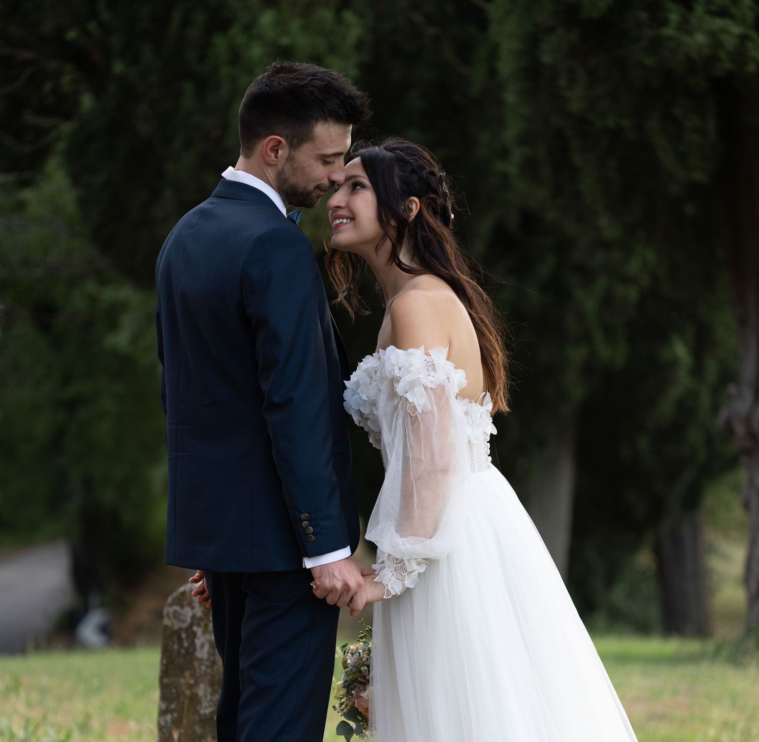 Romantic outdoor wedding photoshoot among trees in a natural setting.