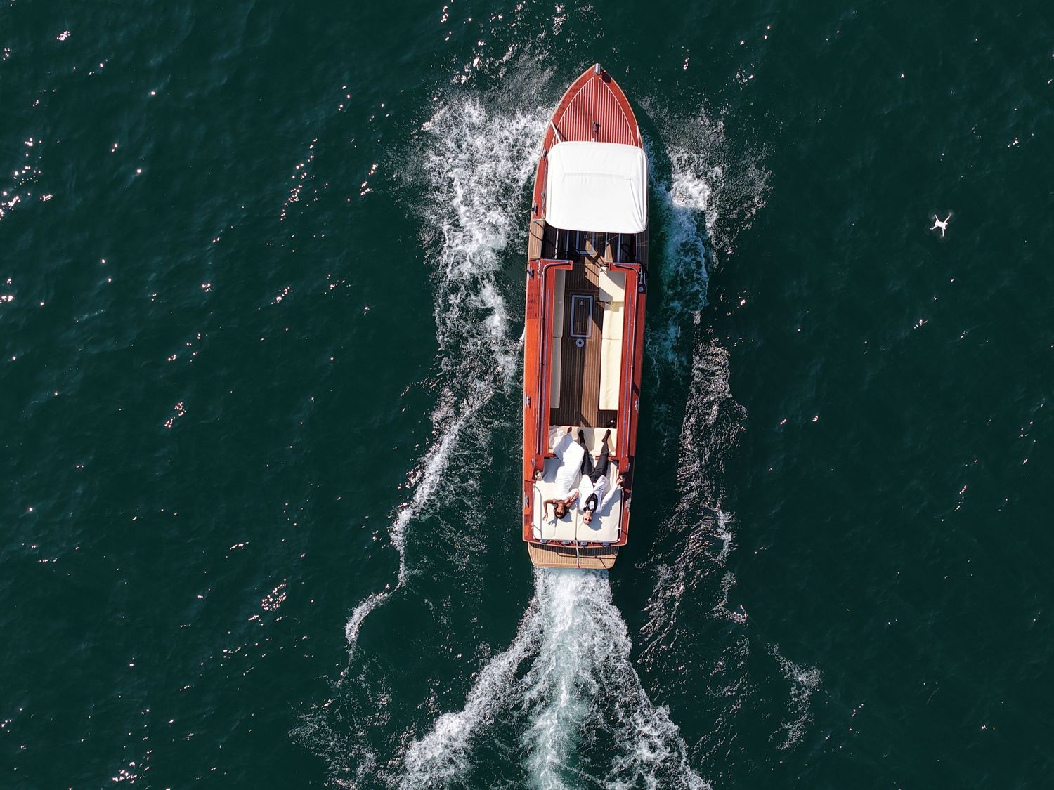 Aerial view of wooden boat cruising through deep blue waters.