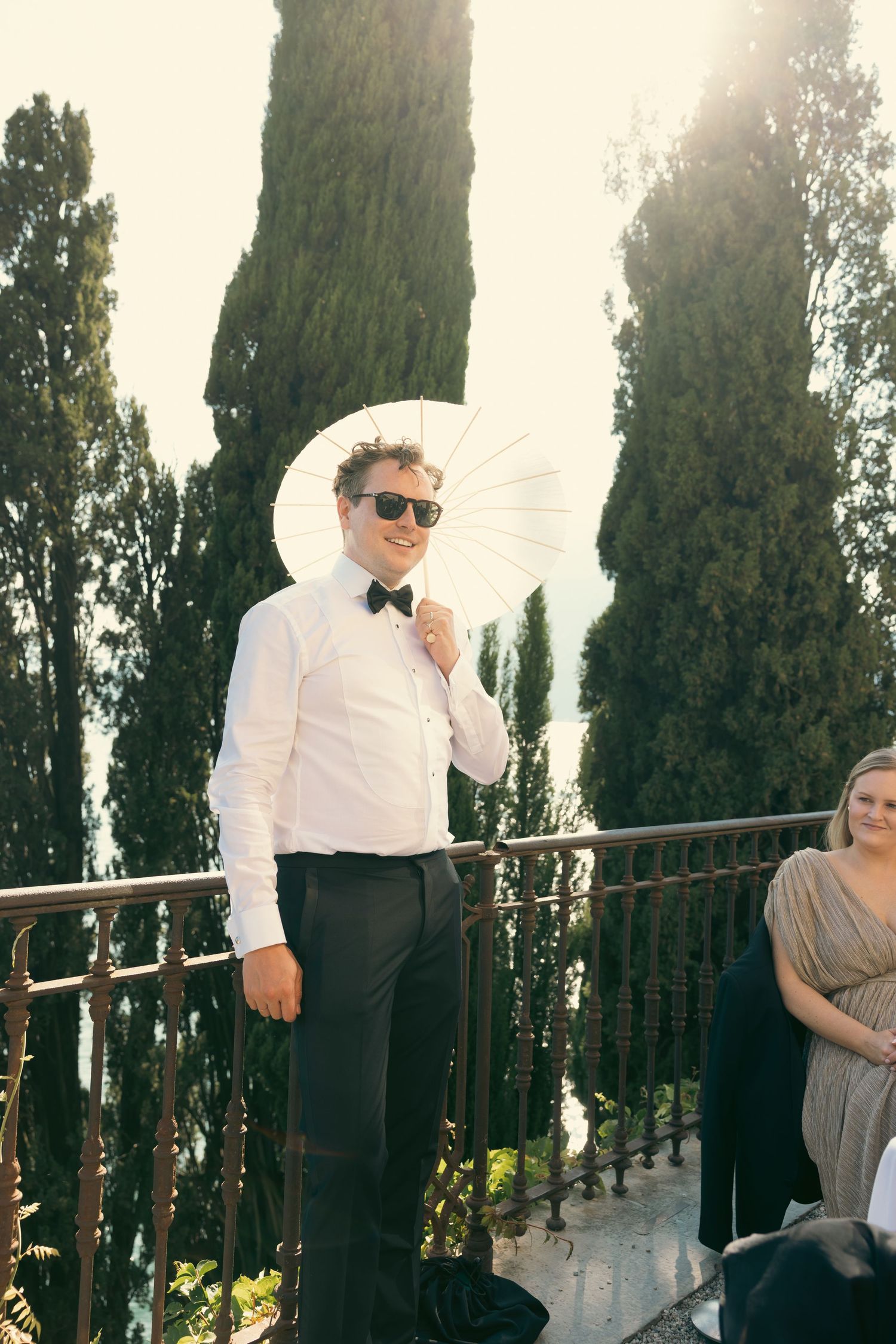 A sequence of four photos showing a couple posing playfully against a backdrop of tall cypress trees at sunset.