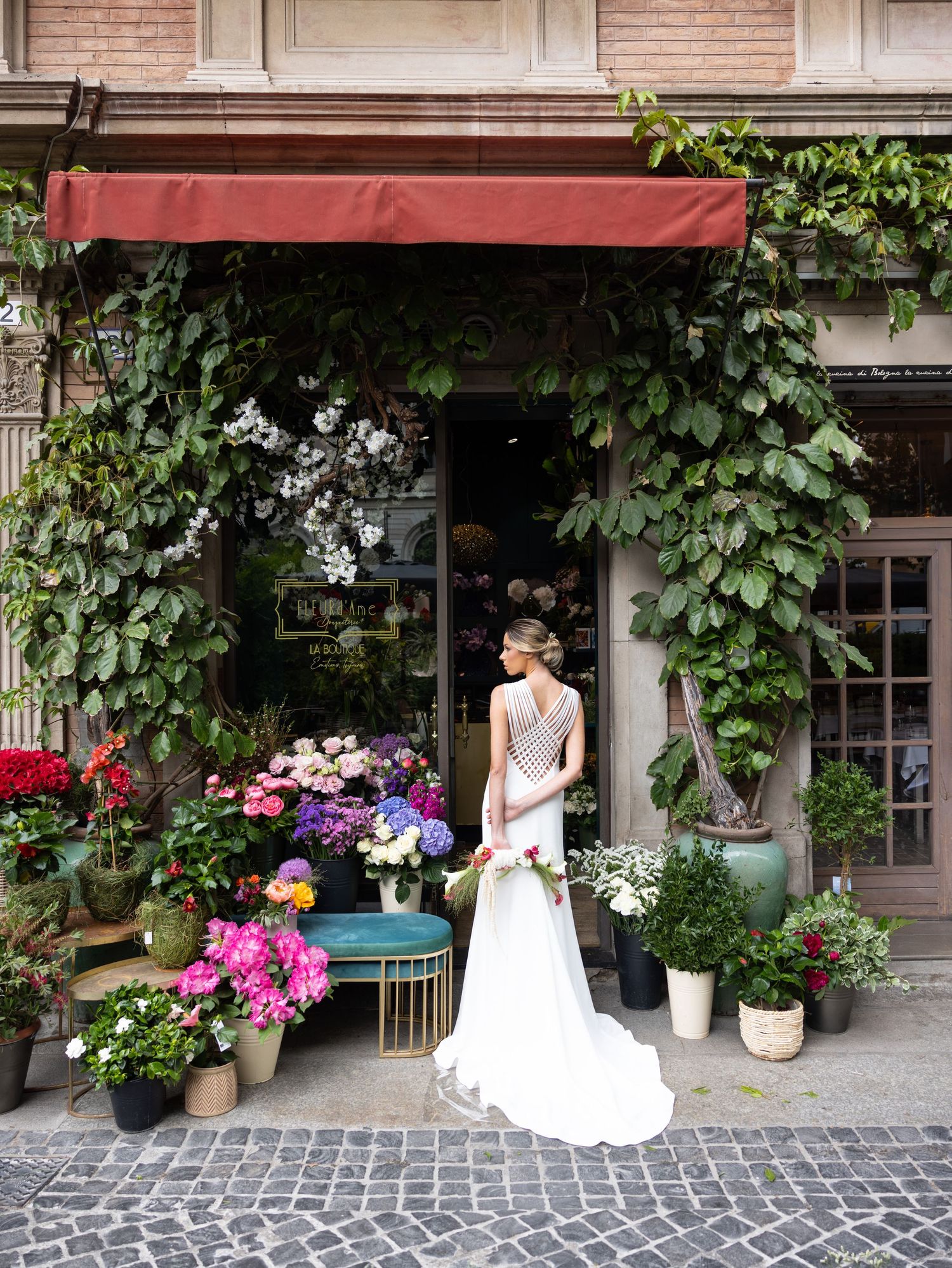Wedding photography at a charming storefront with climbing vines and cobblestone walkway.