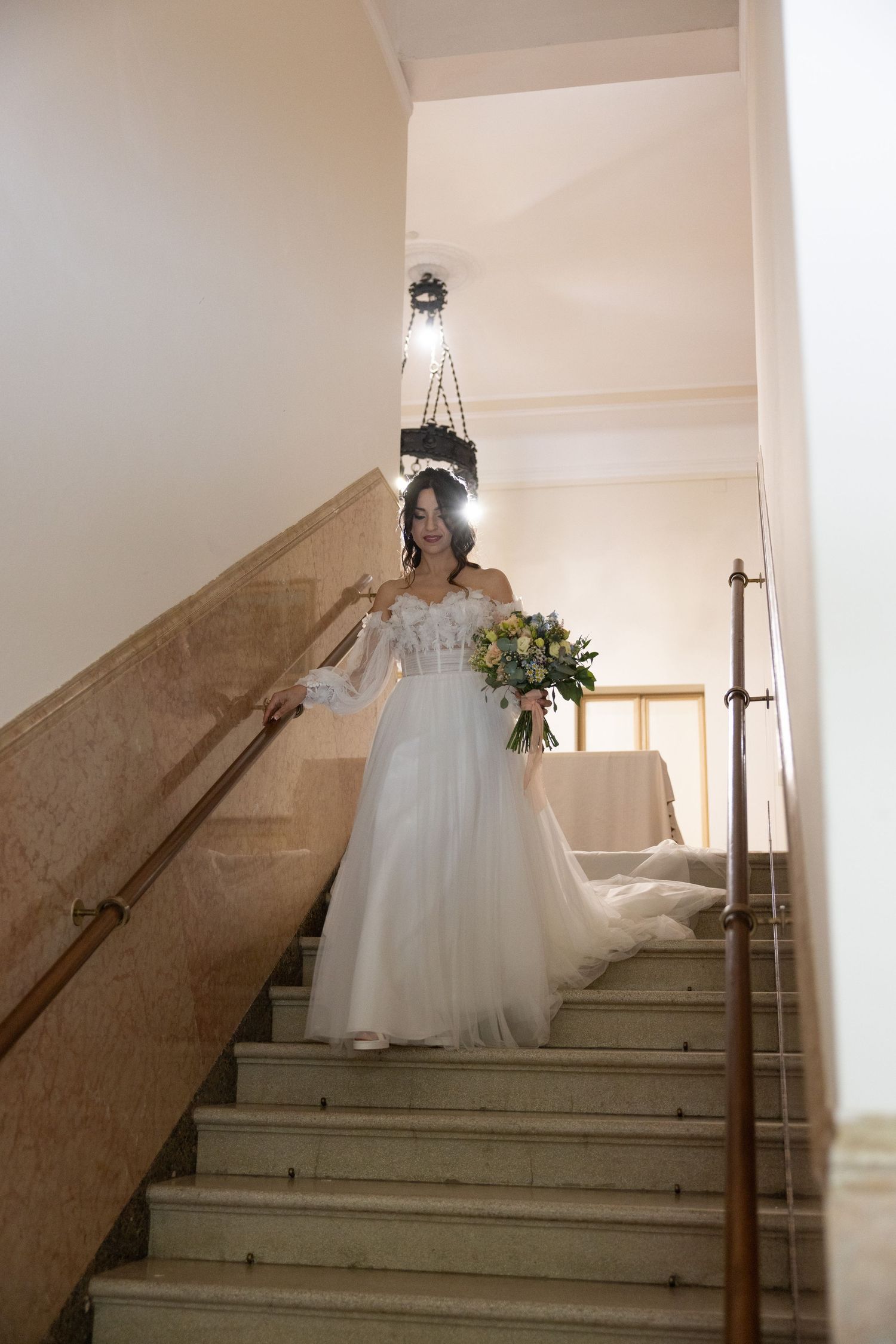 A wedding dress flows down an elegant staircase in a series of artistic shots.