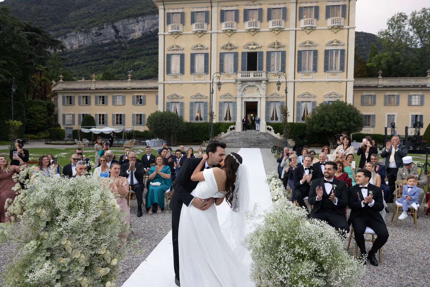 Outdoor wedding ceremony setup with mountain backdrop at an elegant Italian villa.