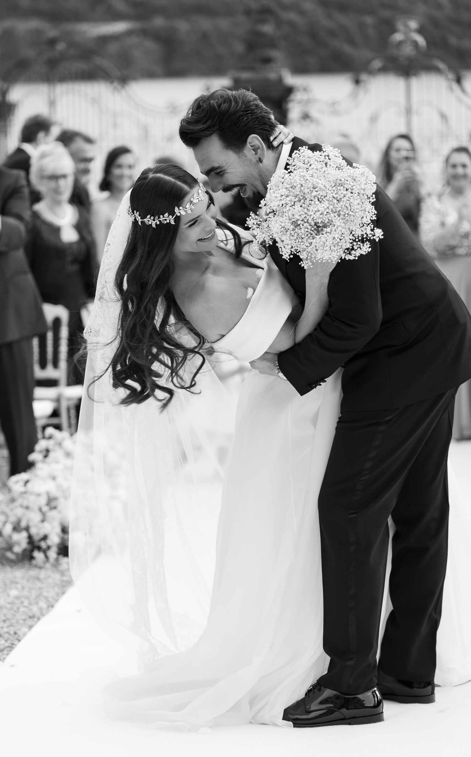 Romantic black and white wedding moment captured in an outdoor garden setting.