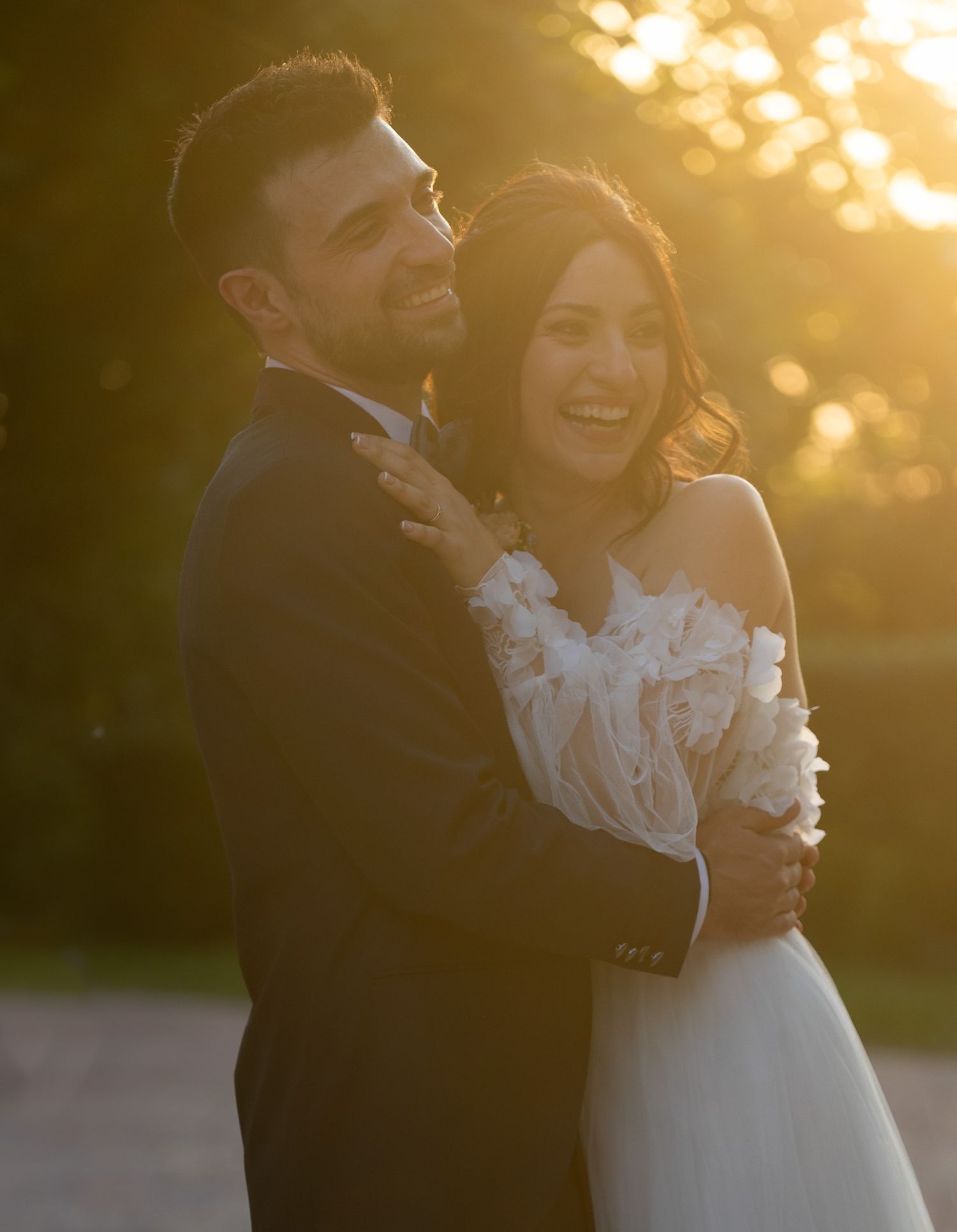 Joyful wedding portrait of a couple laughing together during golden hour.