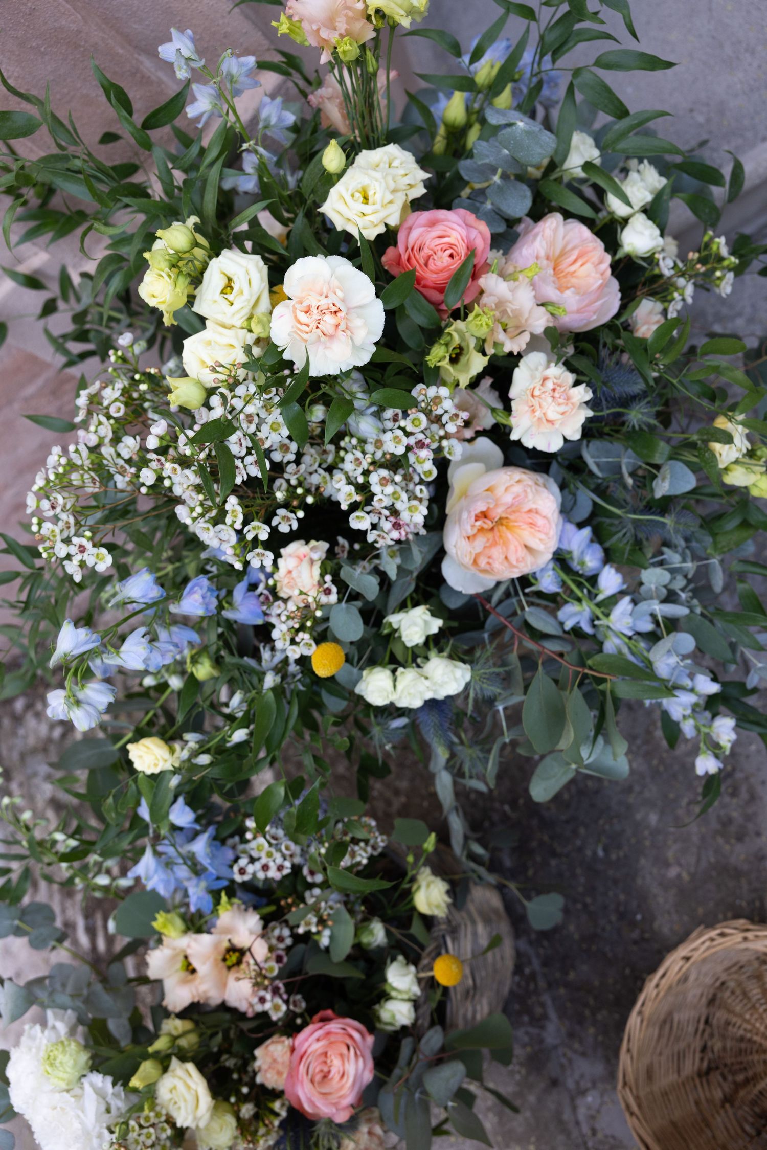Elegant floral arrangement featuring pink roses, white blooms, and delicate greenery for a wedding.