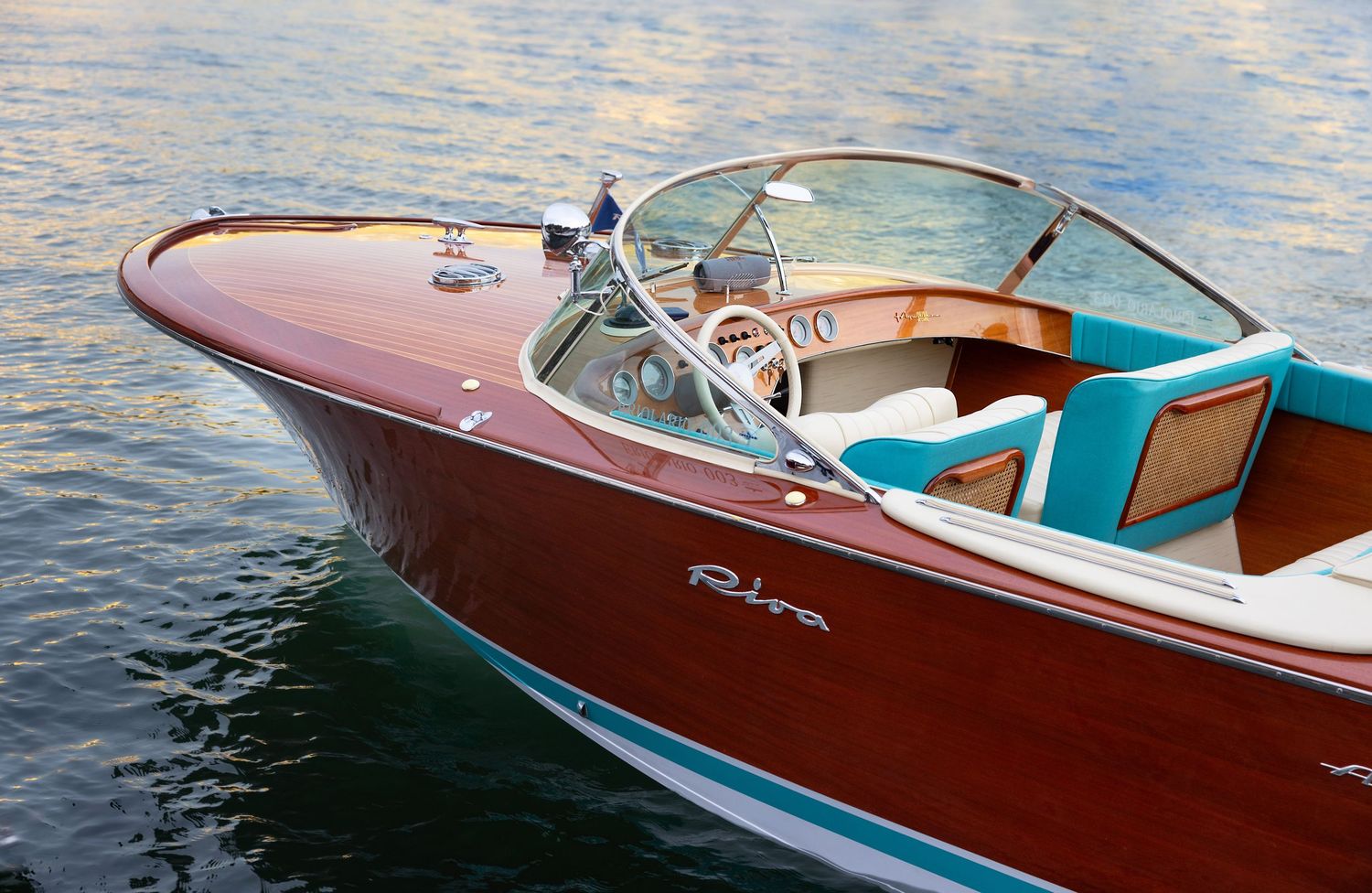 Classic wooden Riva boats with polished mahogany hulls floating on tranquil water.