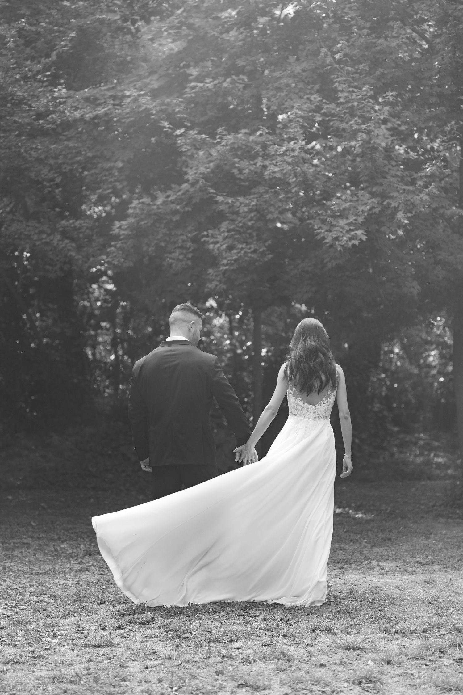 Black and white sequence of flowing wedding dress movement in a natural outdoor setting.