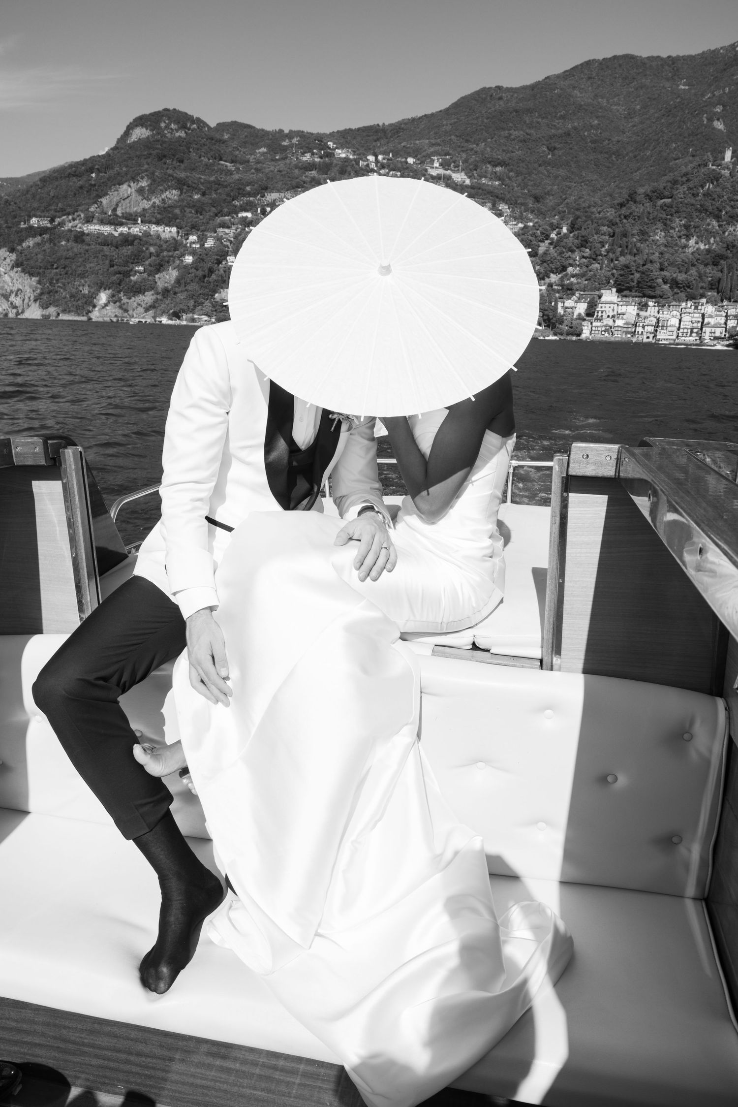 A series of black and white wedding photos showing elegant white dresses against a scenic mountainous backdrop.