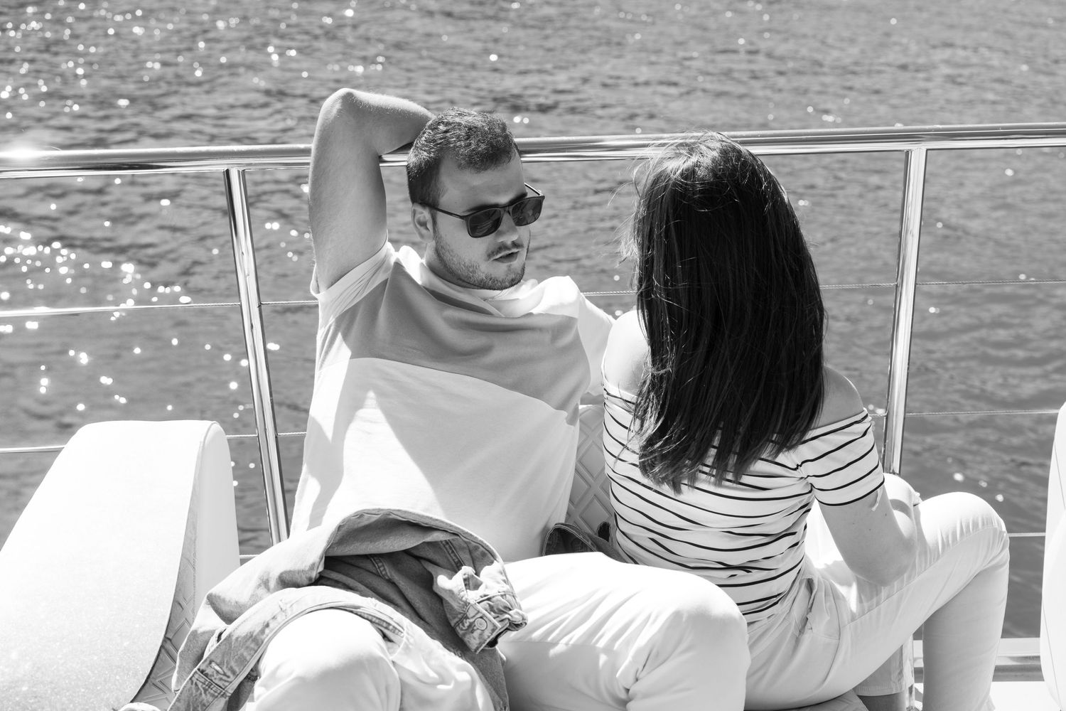 Group relaxing on a luxury yacht with scenic mountain views.