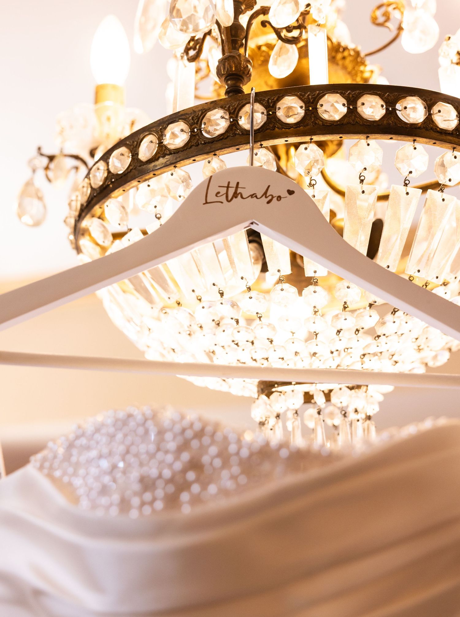 Elegant crystal chandelier with round glass bulbs illuminates a luxurious ceiling with warm golden light.