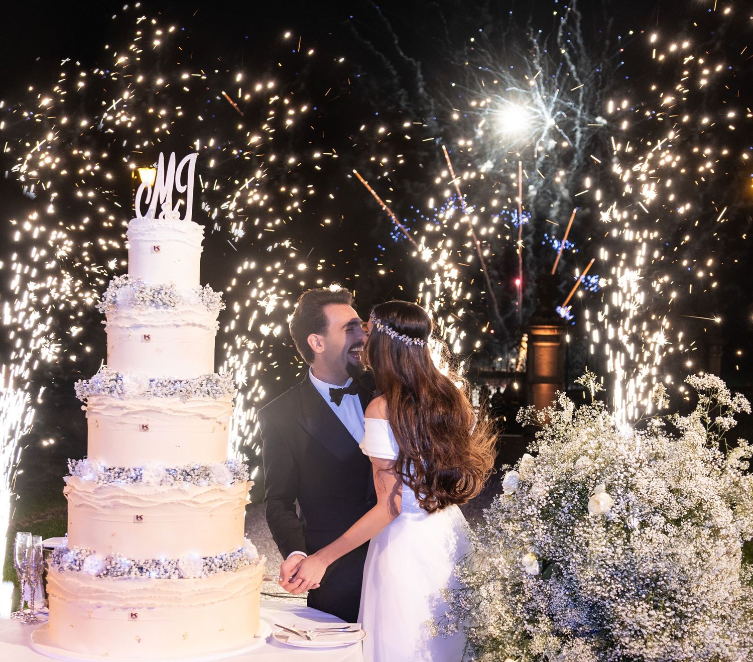 Multi-tiered wedding cake with spectacular sparkler effects creating a magical moment.