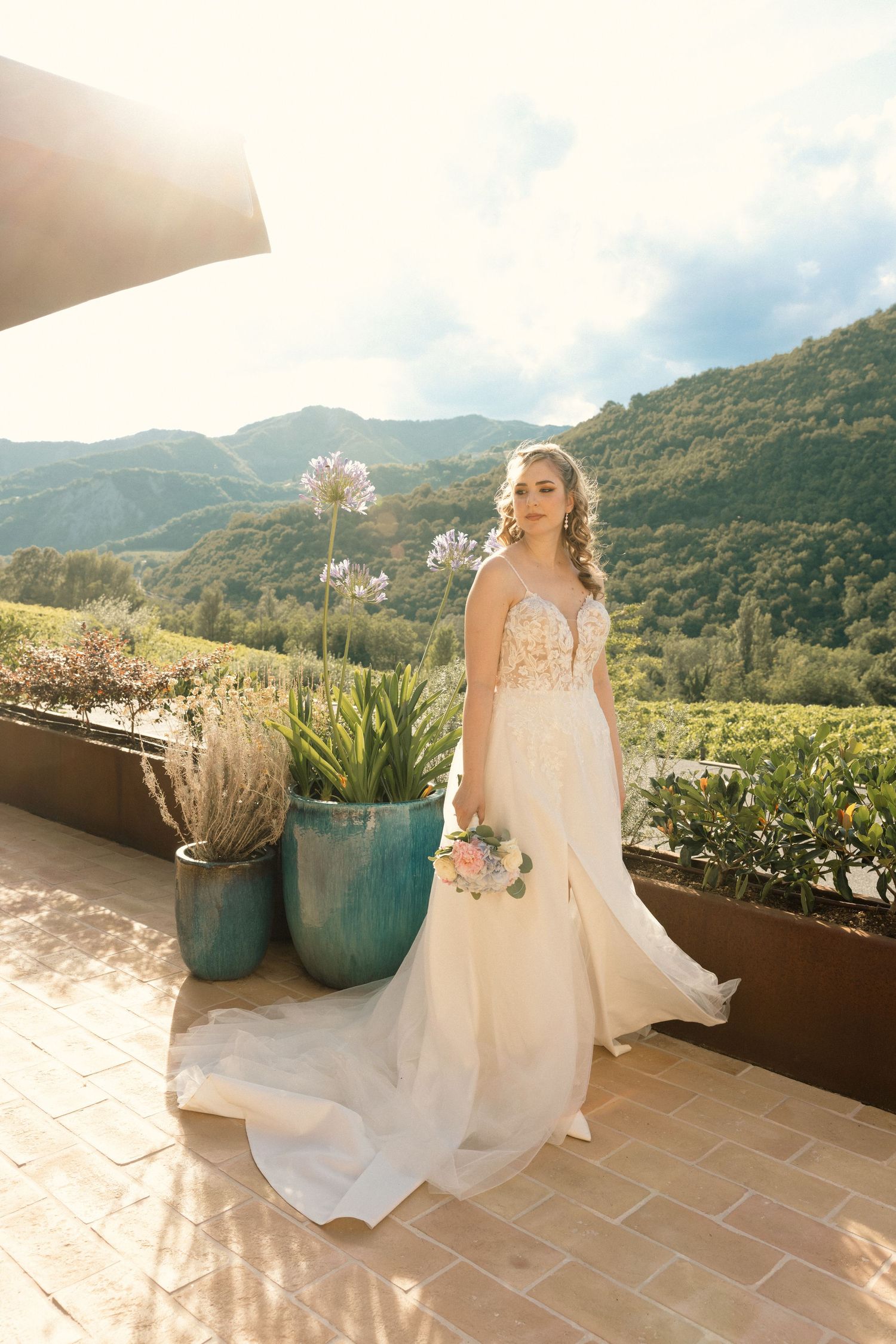 Bridal portraits on a terrace with mountain views and decorative planters.