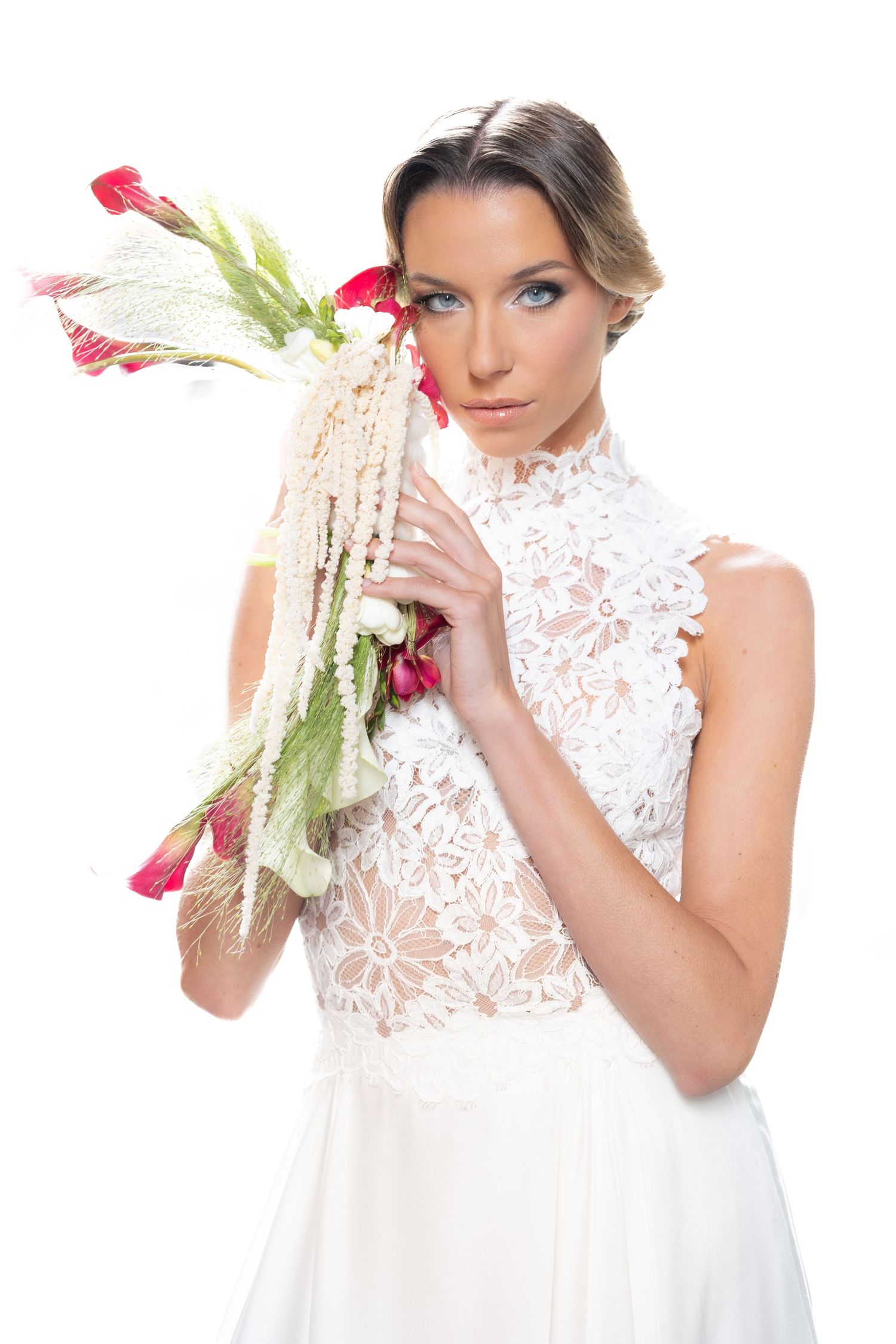 Romantic bridal photos featuring white lace dress and pink floral accents.