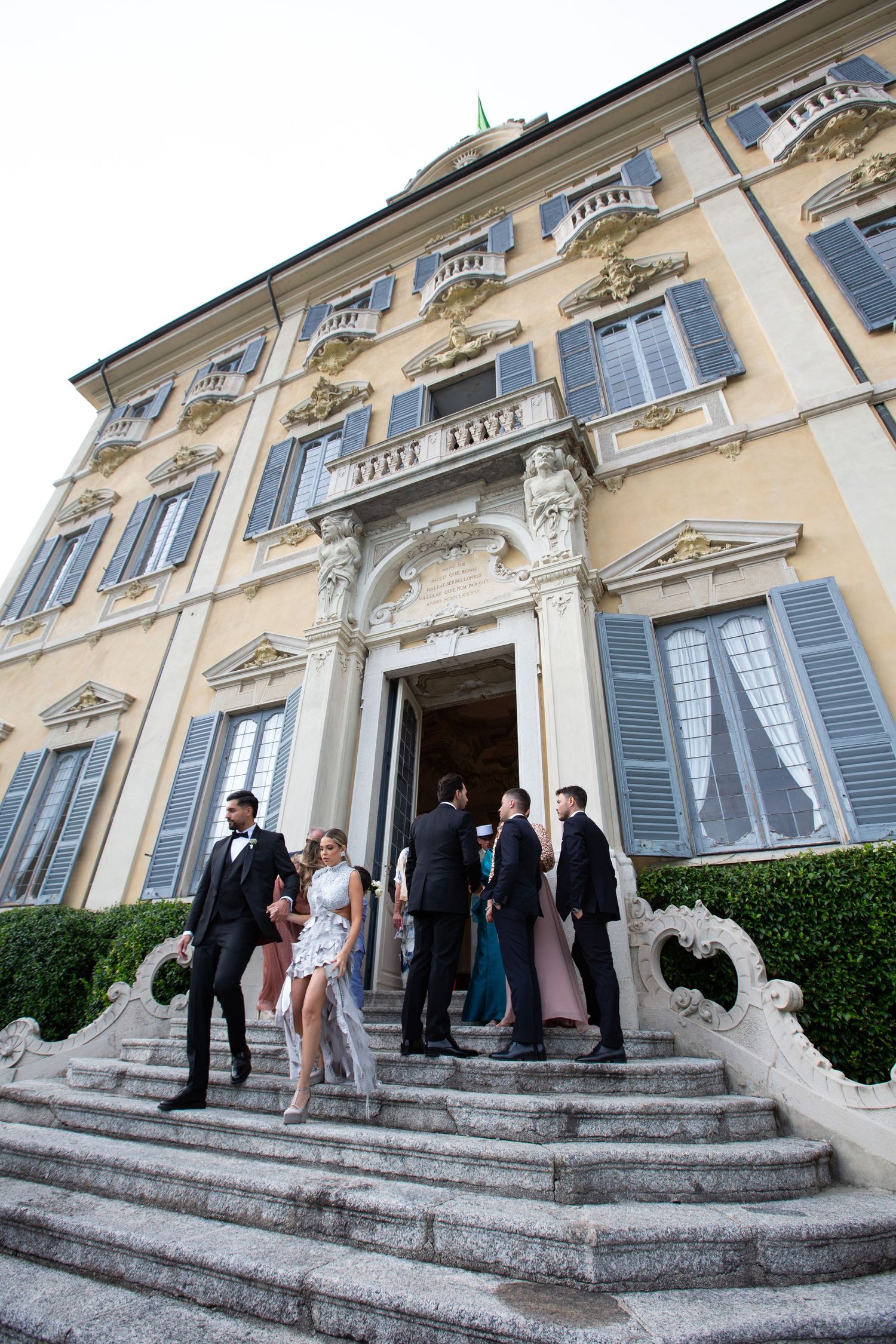 Wedding party gathered on the grand steps of an Italian villa.