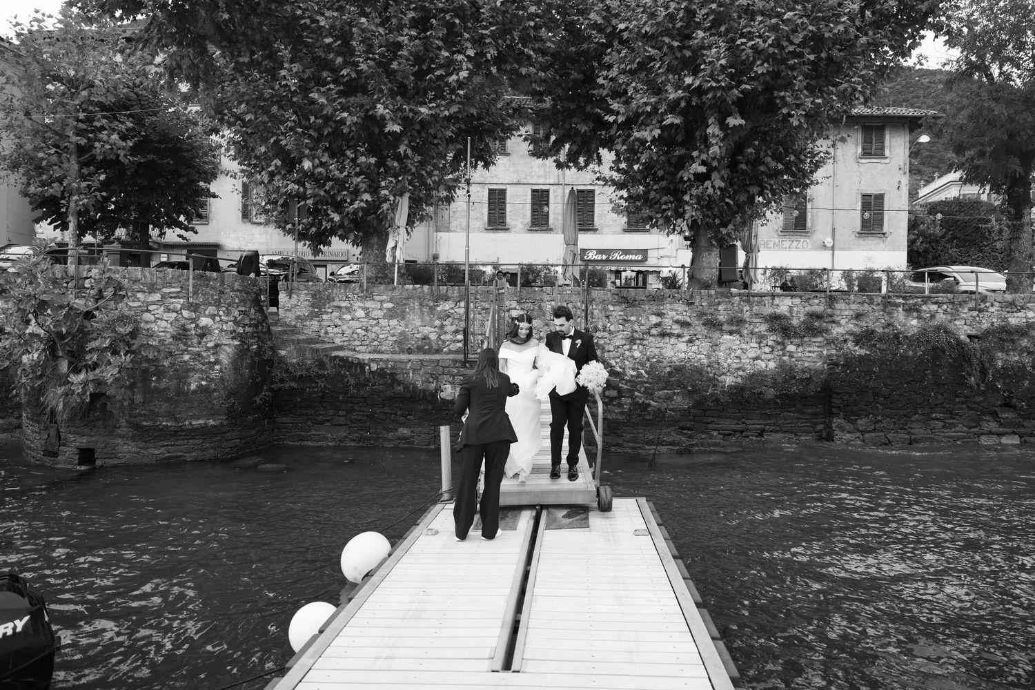 Black and white photo of guests walking along pathway through garden setting.