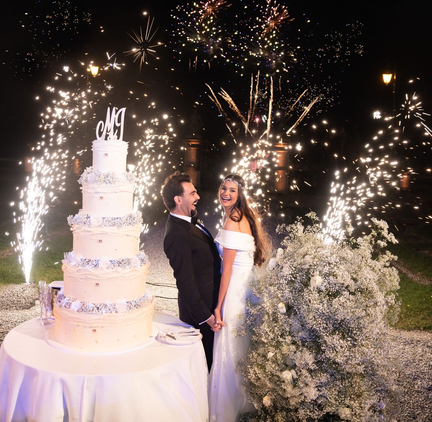 Wedding cake cutting ceremony with dramatic sparkler effects creating a magical atmosphere.