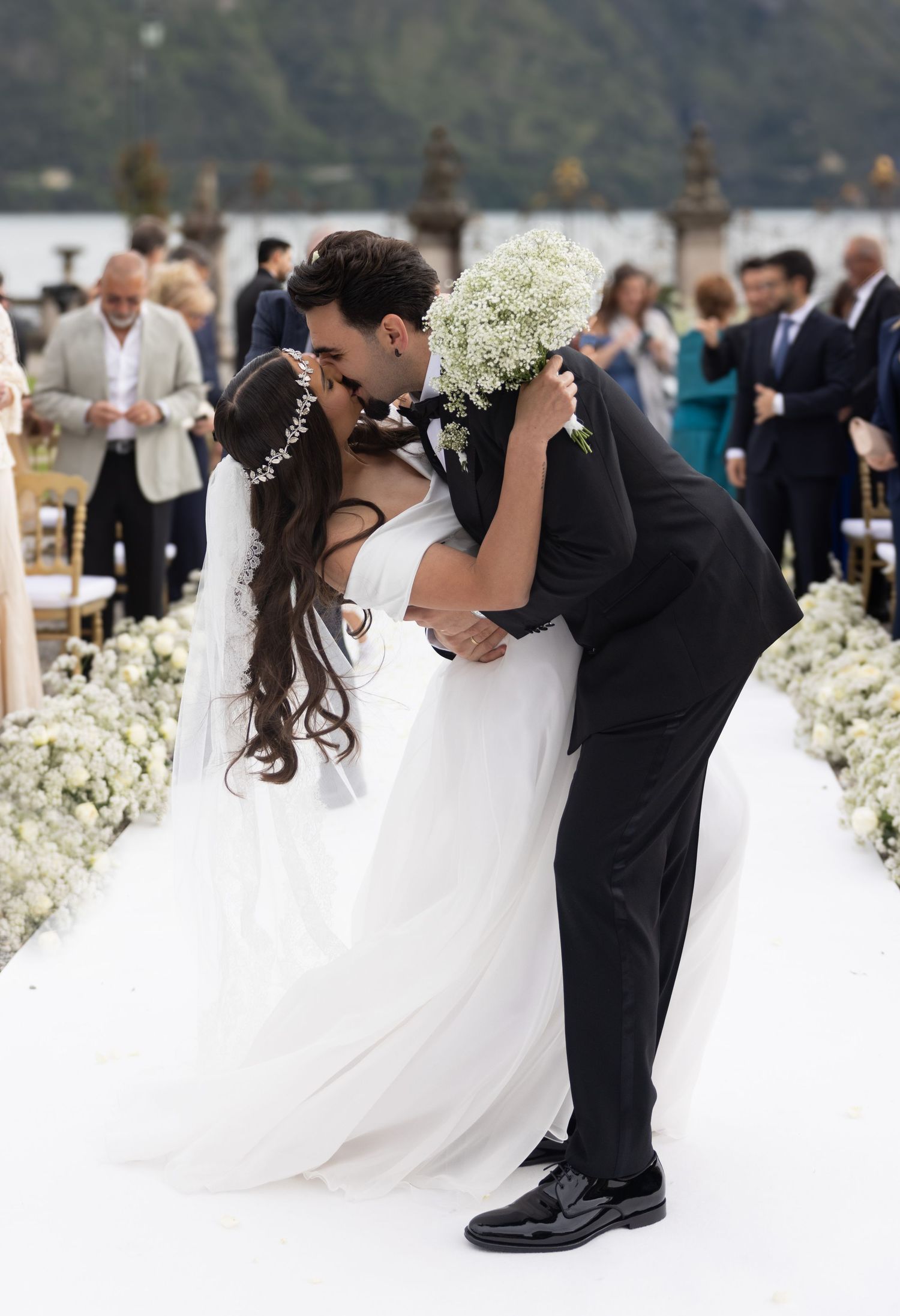 Wedding couple dancing with flowing white dress against mountain backdrop.