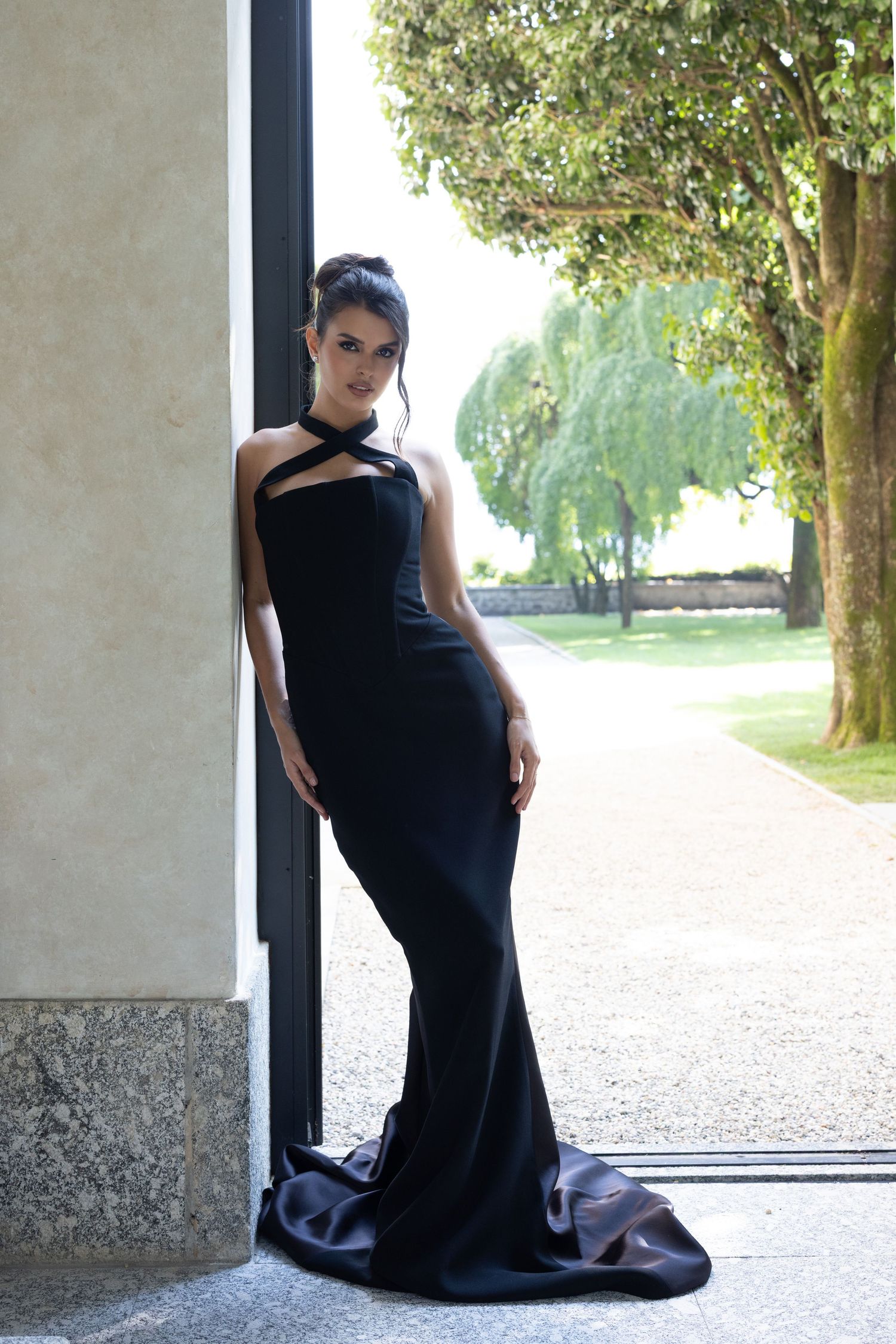 A dramatic fashion photoshoot sequence showing a long black evening gown against a light stone architectural backdrop.