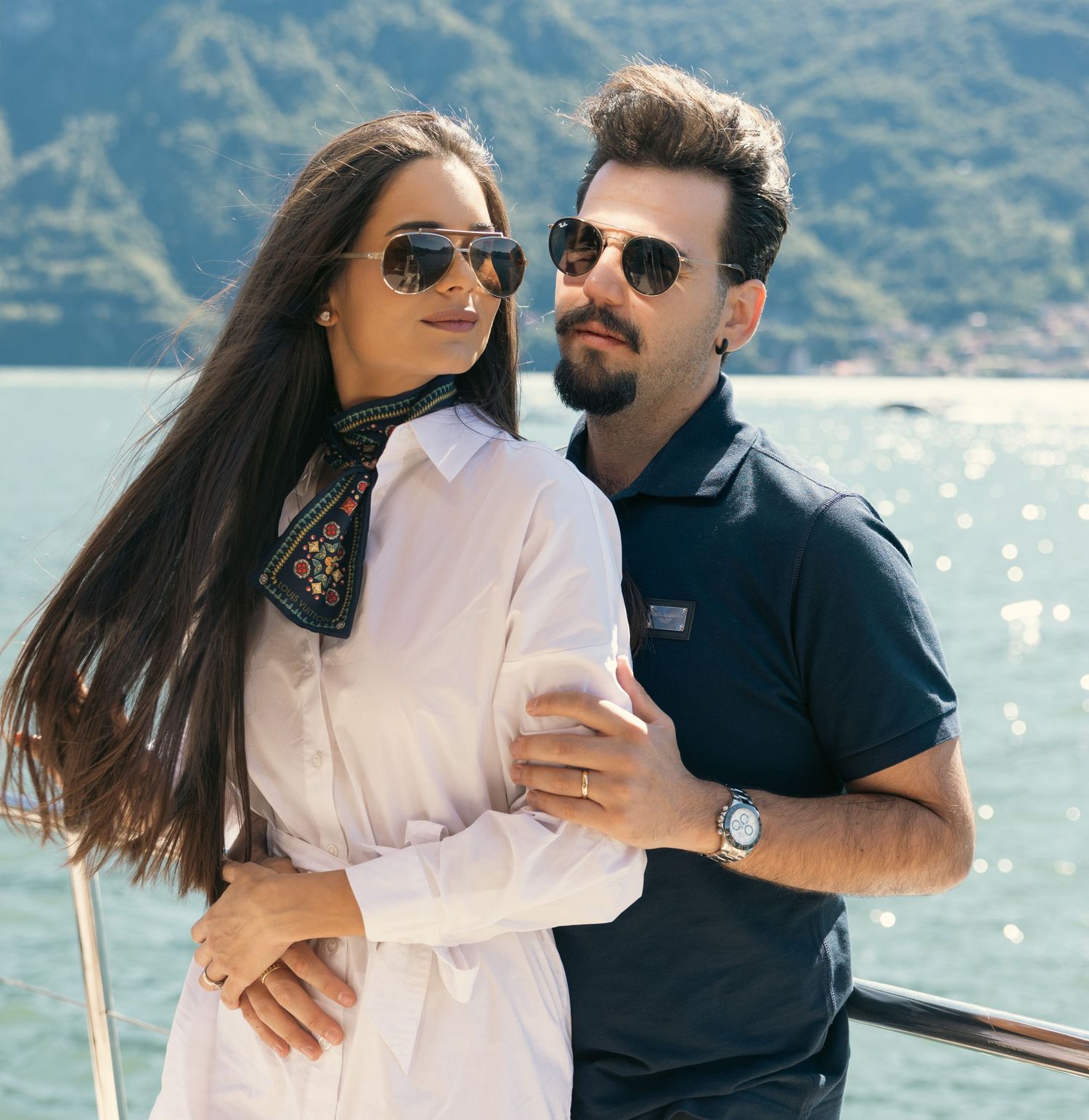 Series of affectionate moments captured on a boat with mountainous backdrop and sunlit water.