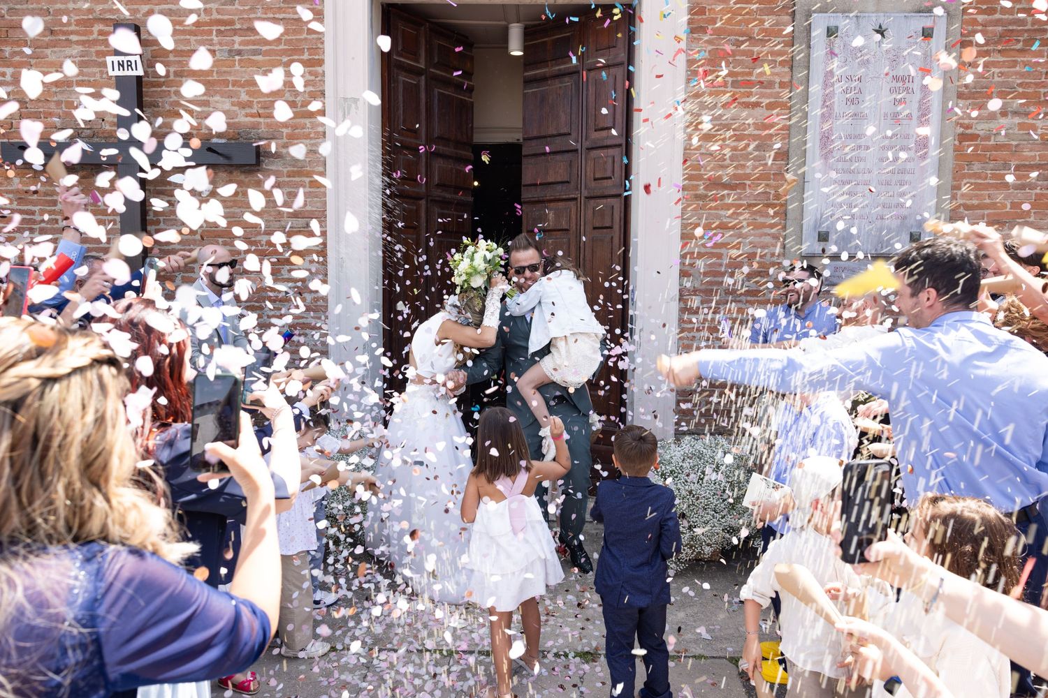 Celebratory confetti shower fills the air during a wedding exit at a historic venue.