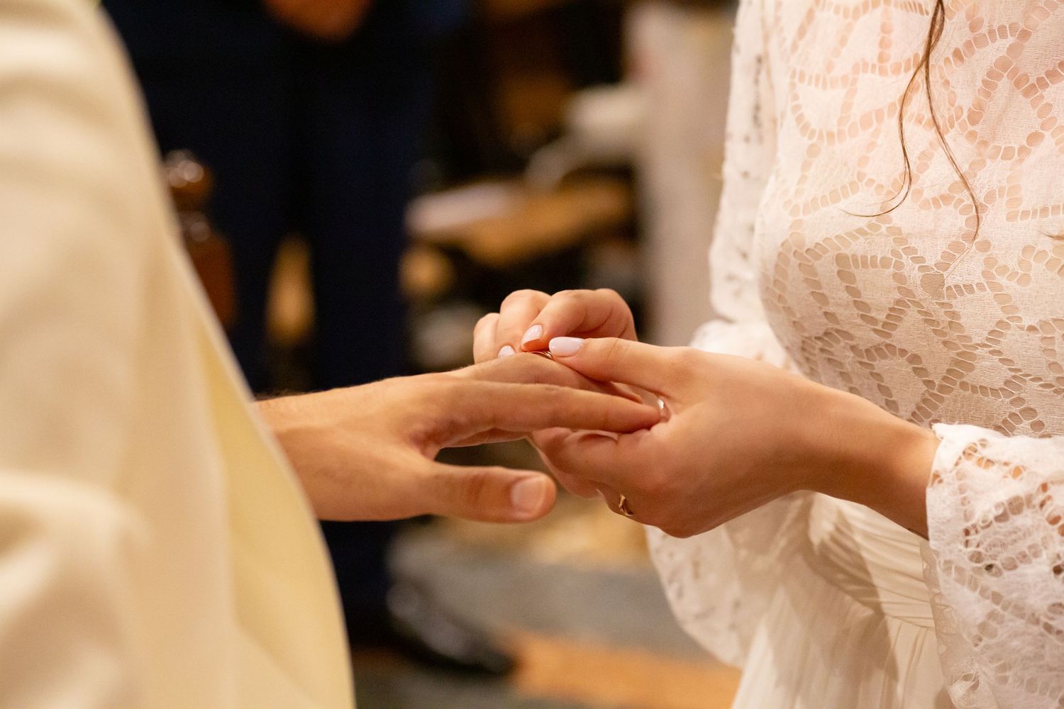 Close up of hands exchanging wedding rings during a ceremony.