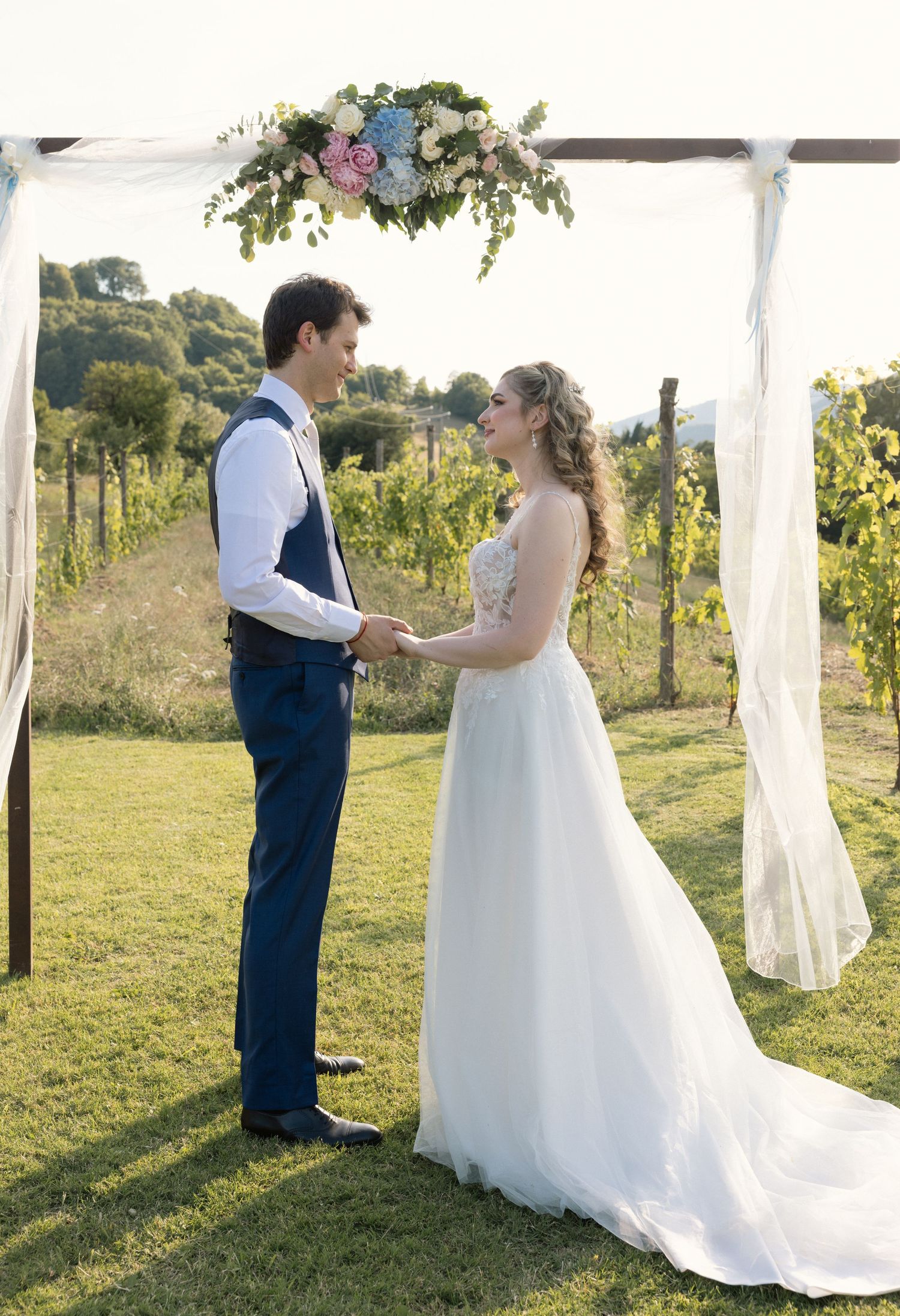 Wedding ceremony sequence in a beautiful vineyard with white drapes and mountain backdrop.