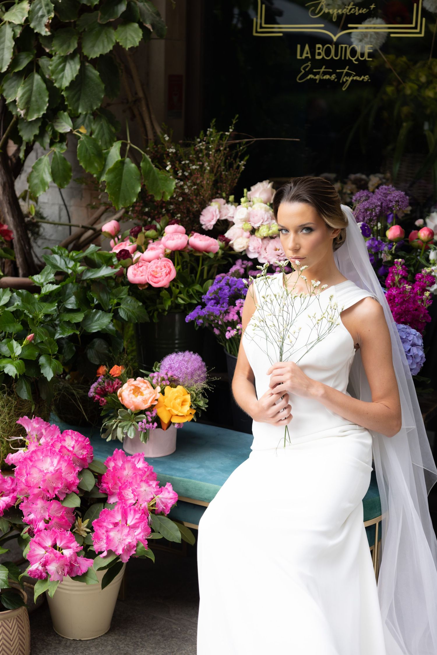 Wedding photography session showcasing a white gown against pink and purple floral arrangements.