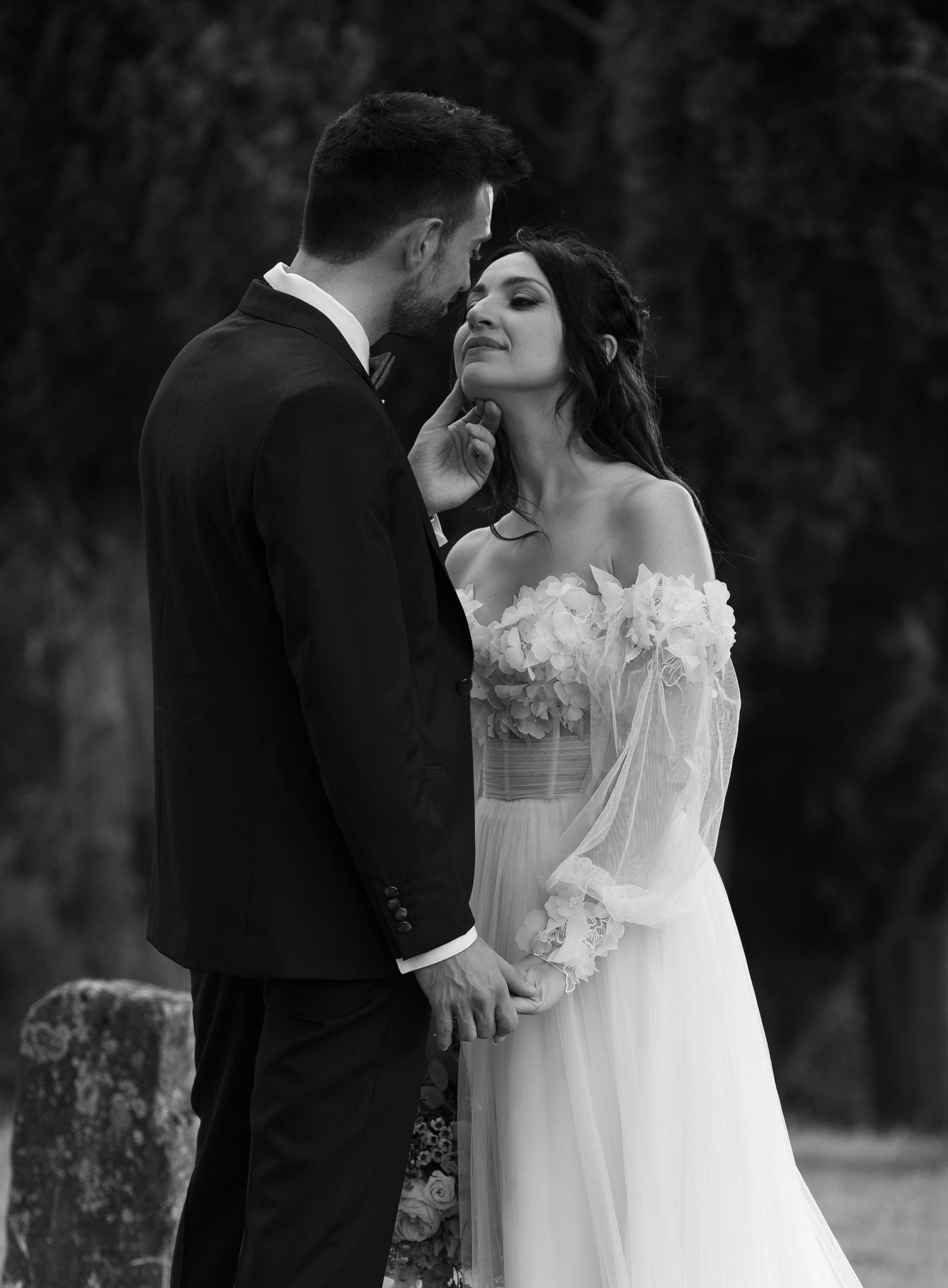 Romantic black and white wedding portrait in an outdoor setting.