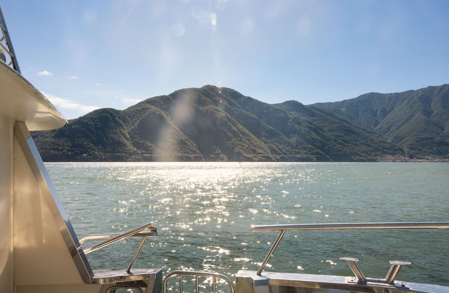 Stunning panoramic view of a mountain lake with sparkling water and clear blue skies.
