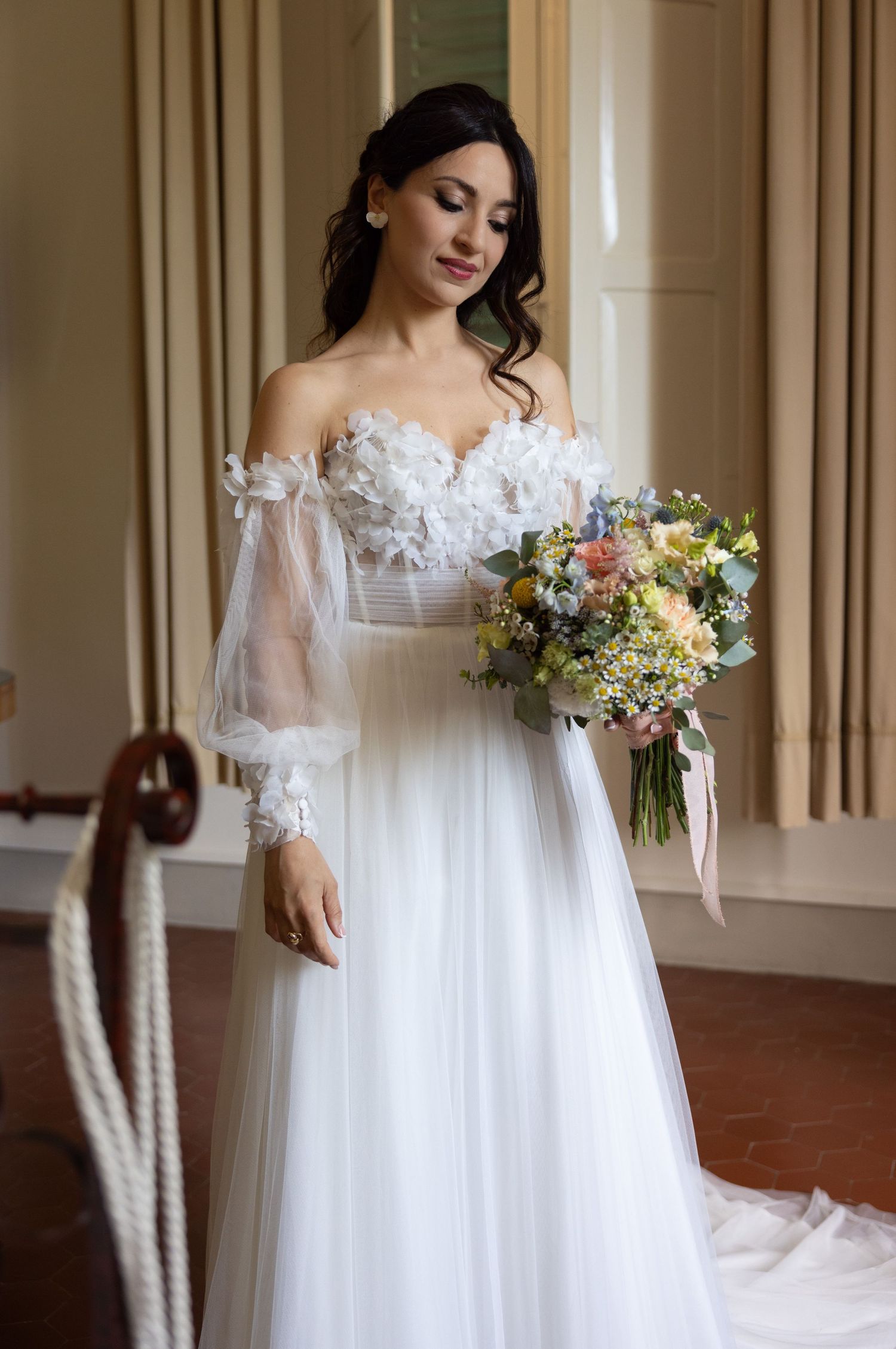 Ethereal white wedding gown with delicate lace details and flowing bouquet.