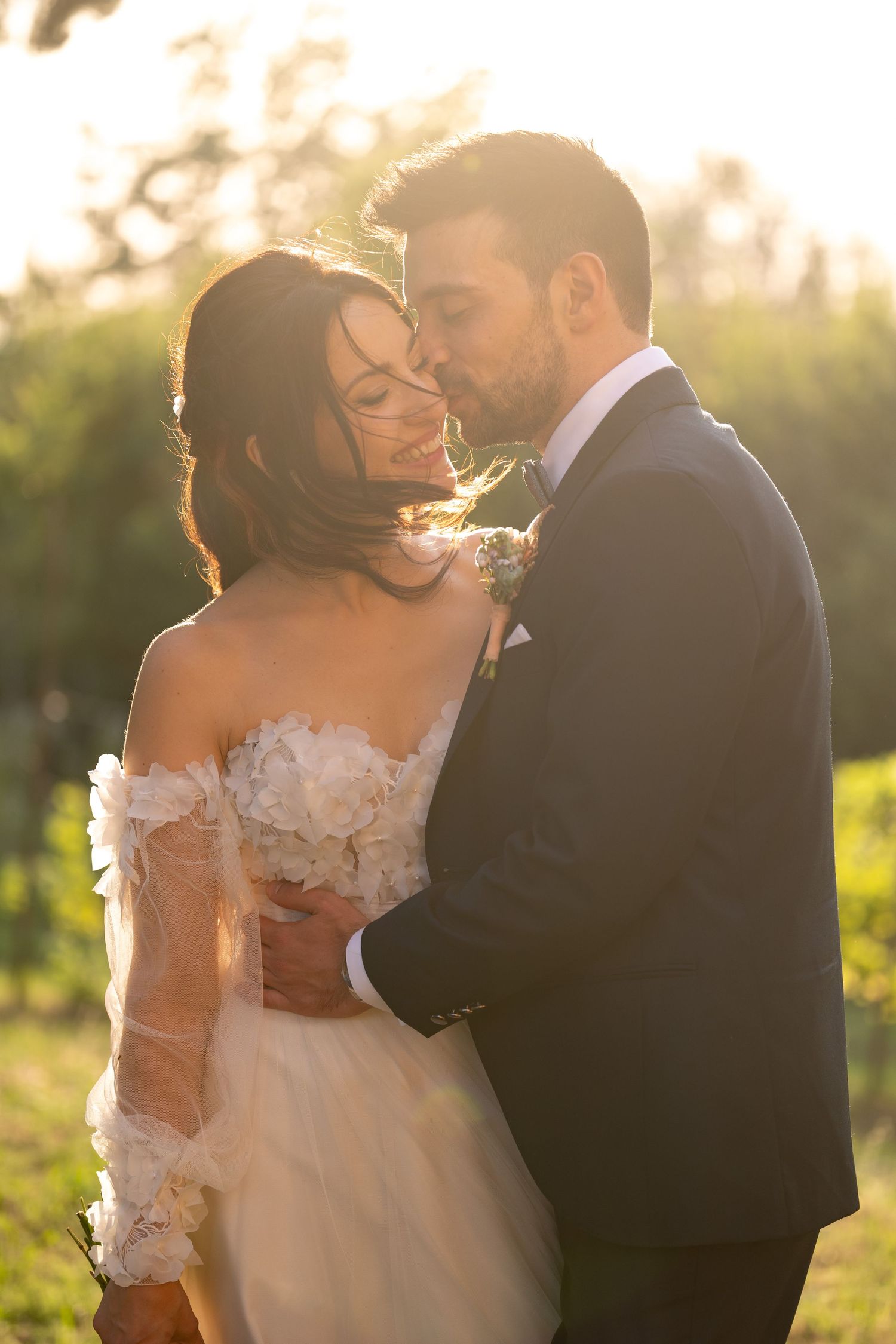 Backlit wedding portrait of a couple sharing an intimate moment during golden hour.