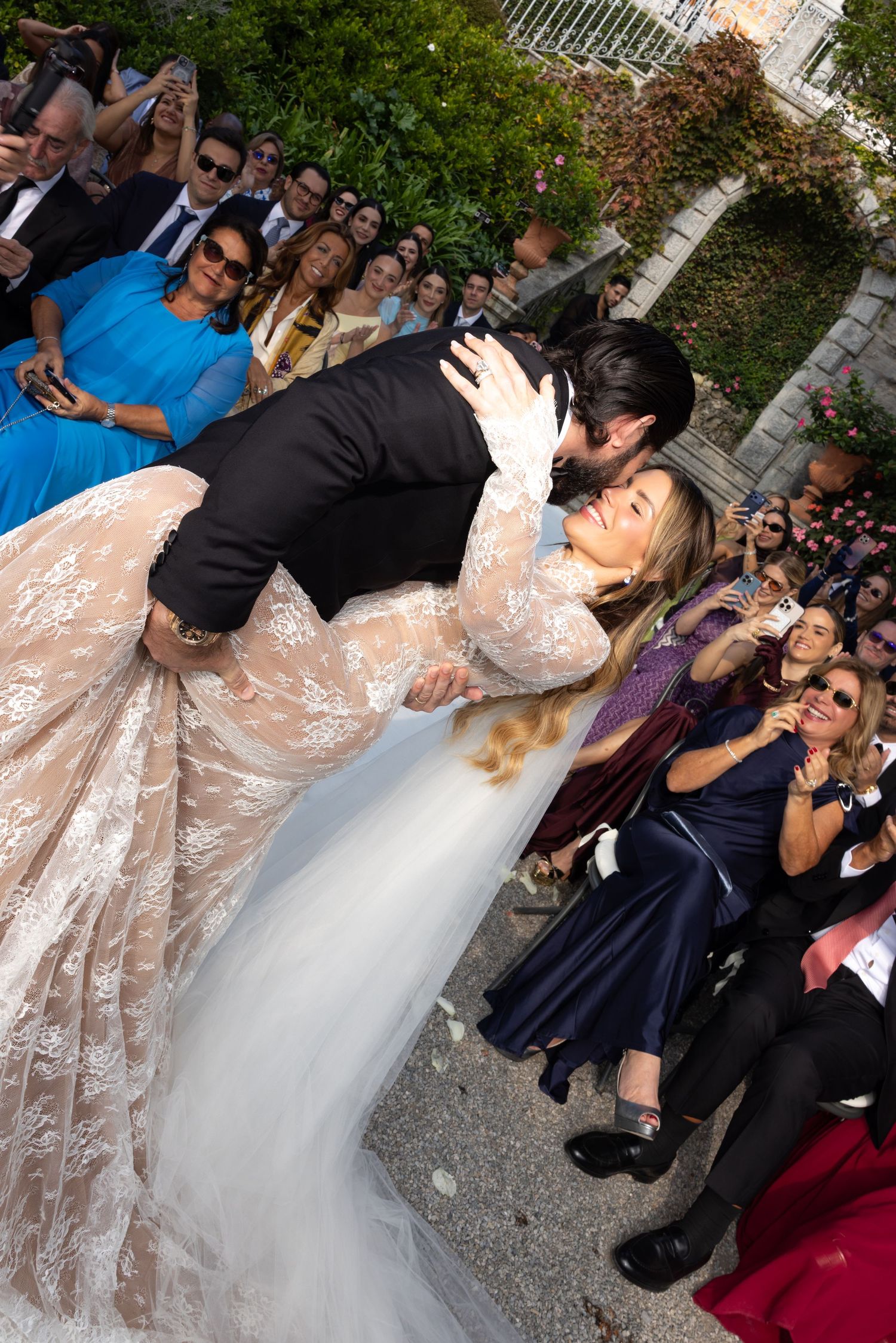 Wedding celebration scene with dancing and guests in an outdoor garden setting.