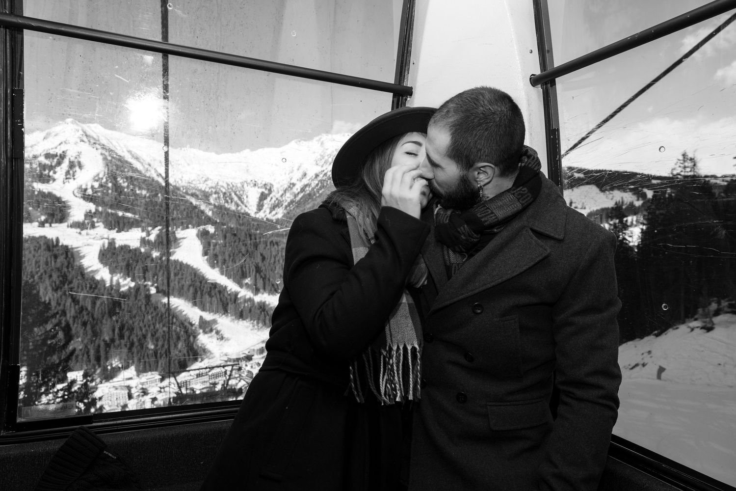 Snow-capped mountain peaks visible through a ski lift window in winter.