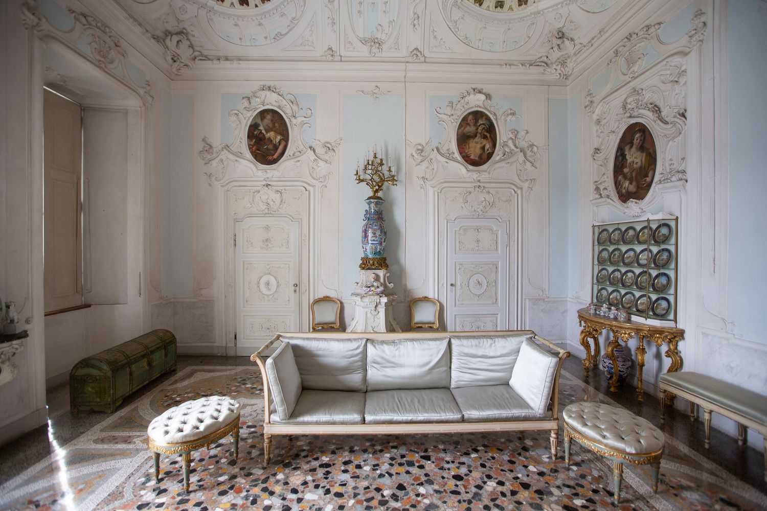Ornate white room interior with classical architectural details and gilded moldings.