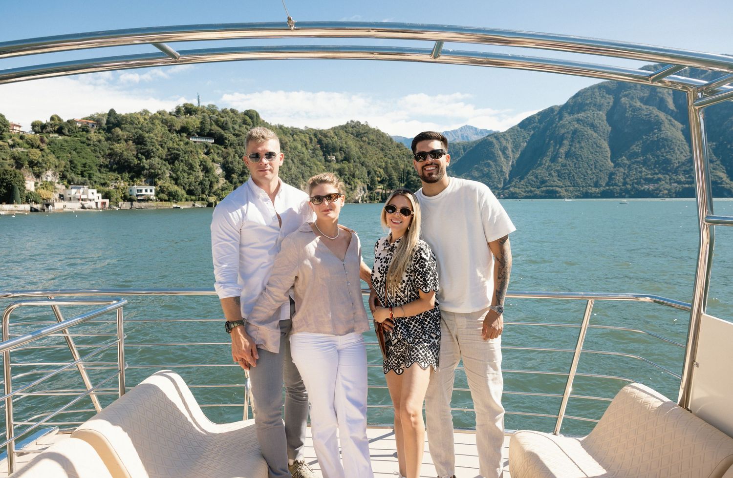 Panoramic view of people enjoying a boat ride on a lake surrounded by mountains.