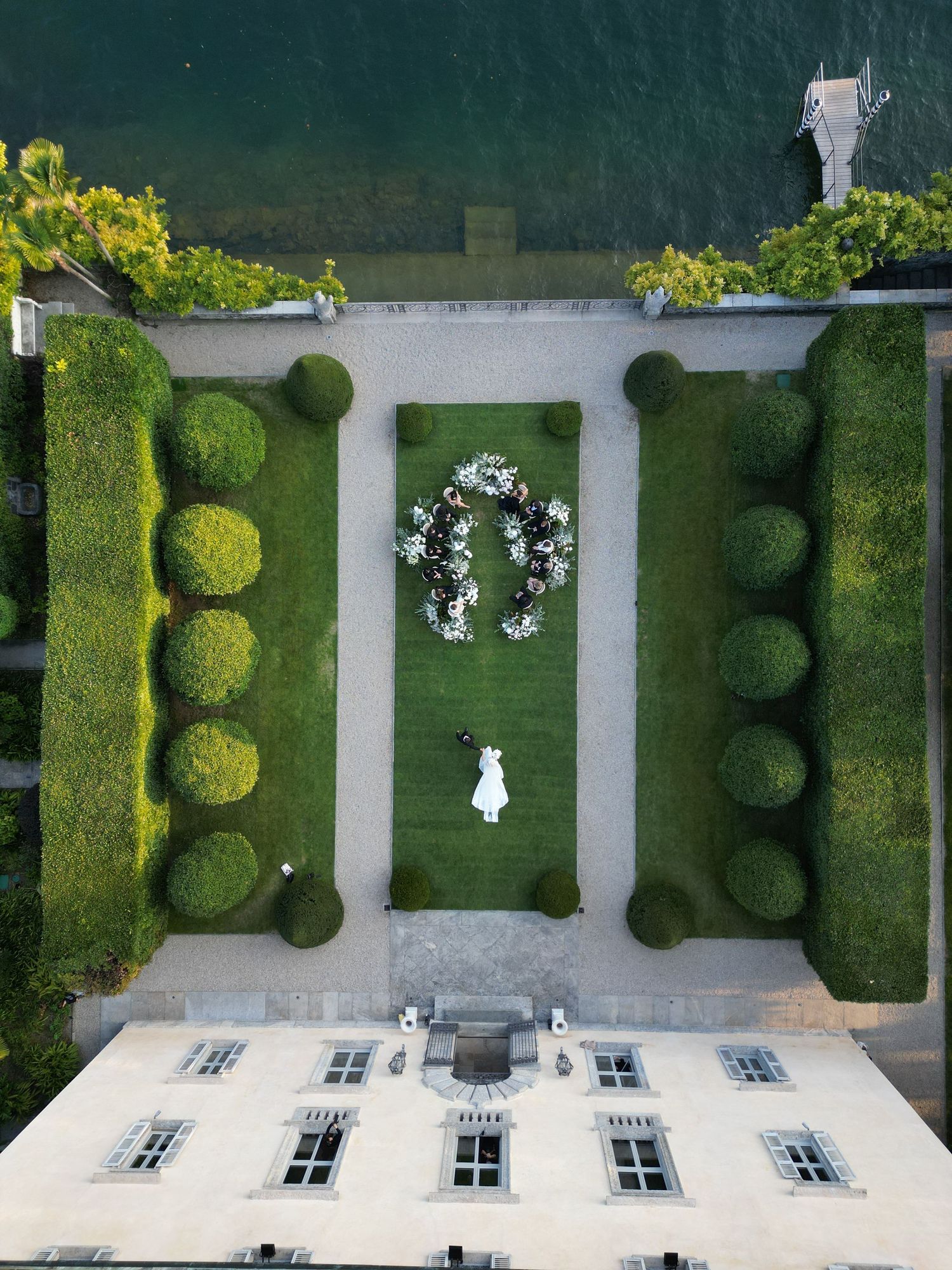 Aerial view of Villa Balbiano with a symmetrical garden layout with manicured hedges, white pathways and geometric patterns.