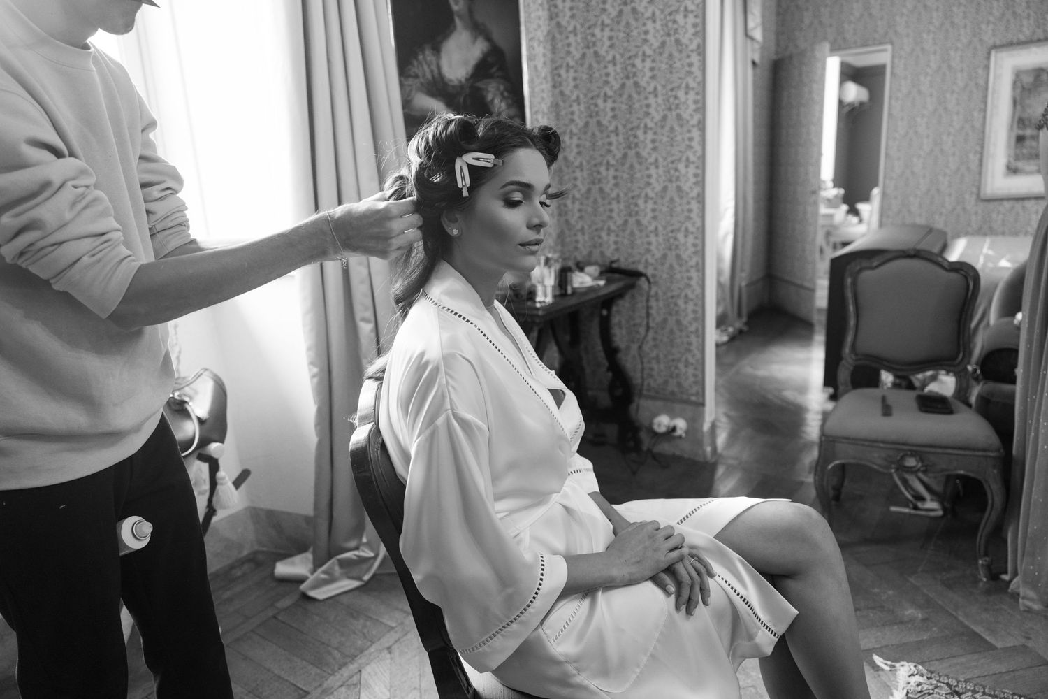 Black and white getting ready scene with white robes and preparations for a wedding day.